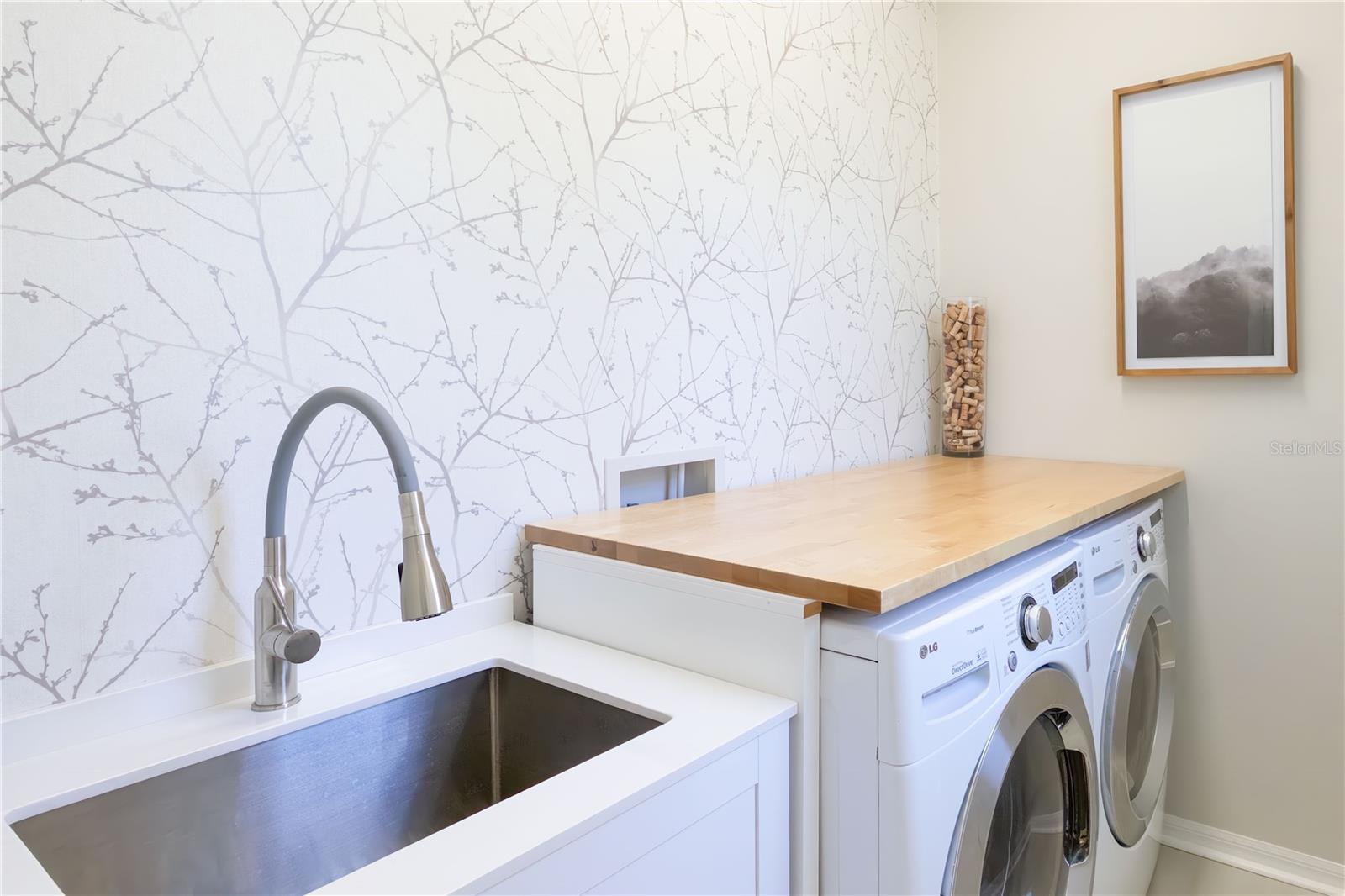 Laundry room features a laundry sink & butcher block counter over the full size washer & dryer!