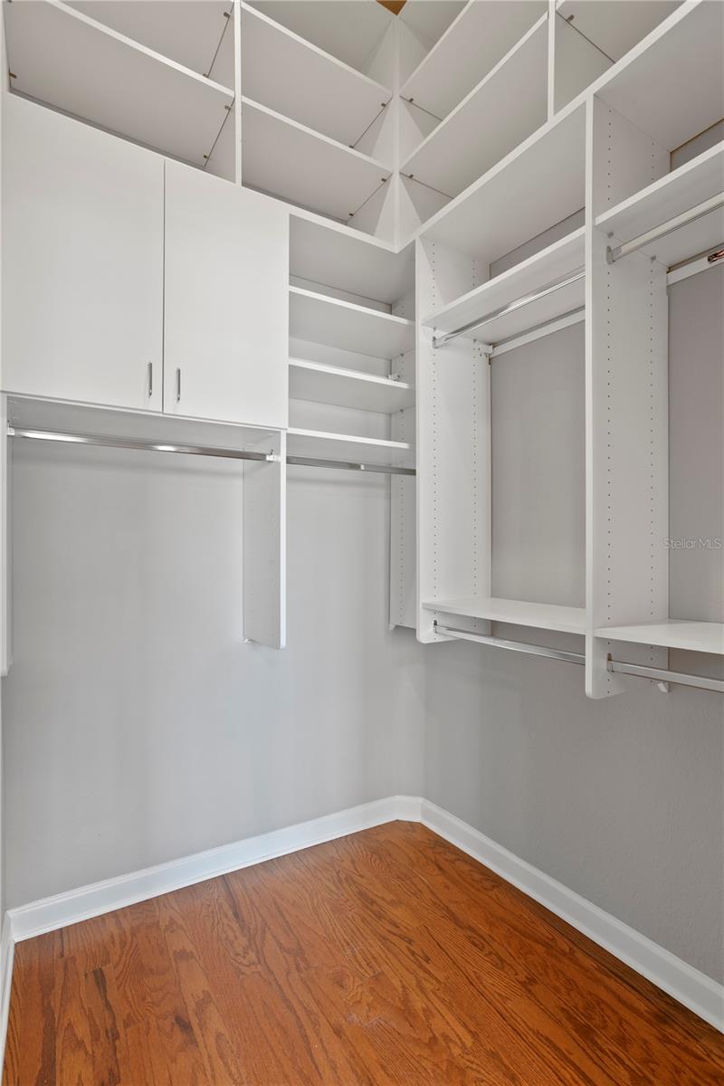 Large primary bedroom walk in closet with organized space