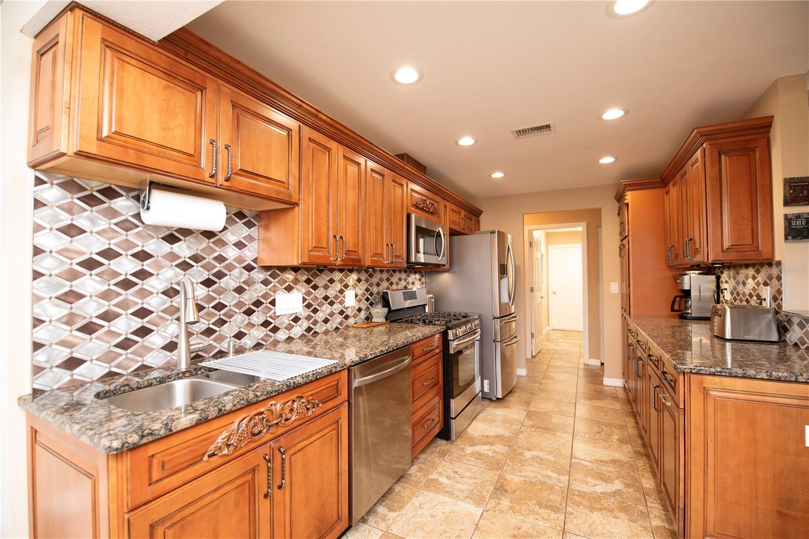 Kitchen with wood cabinets and downlighting.