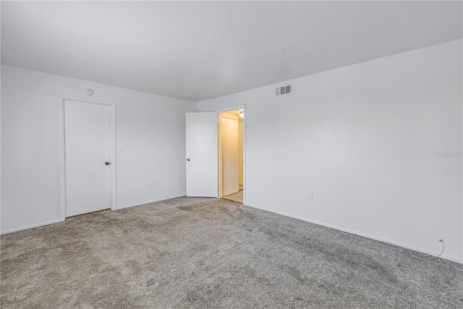 Primary bedroom with new carpeting.