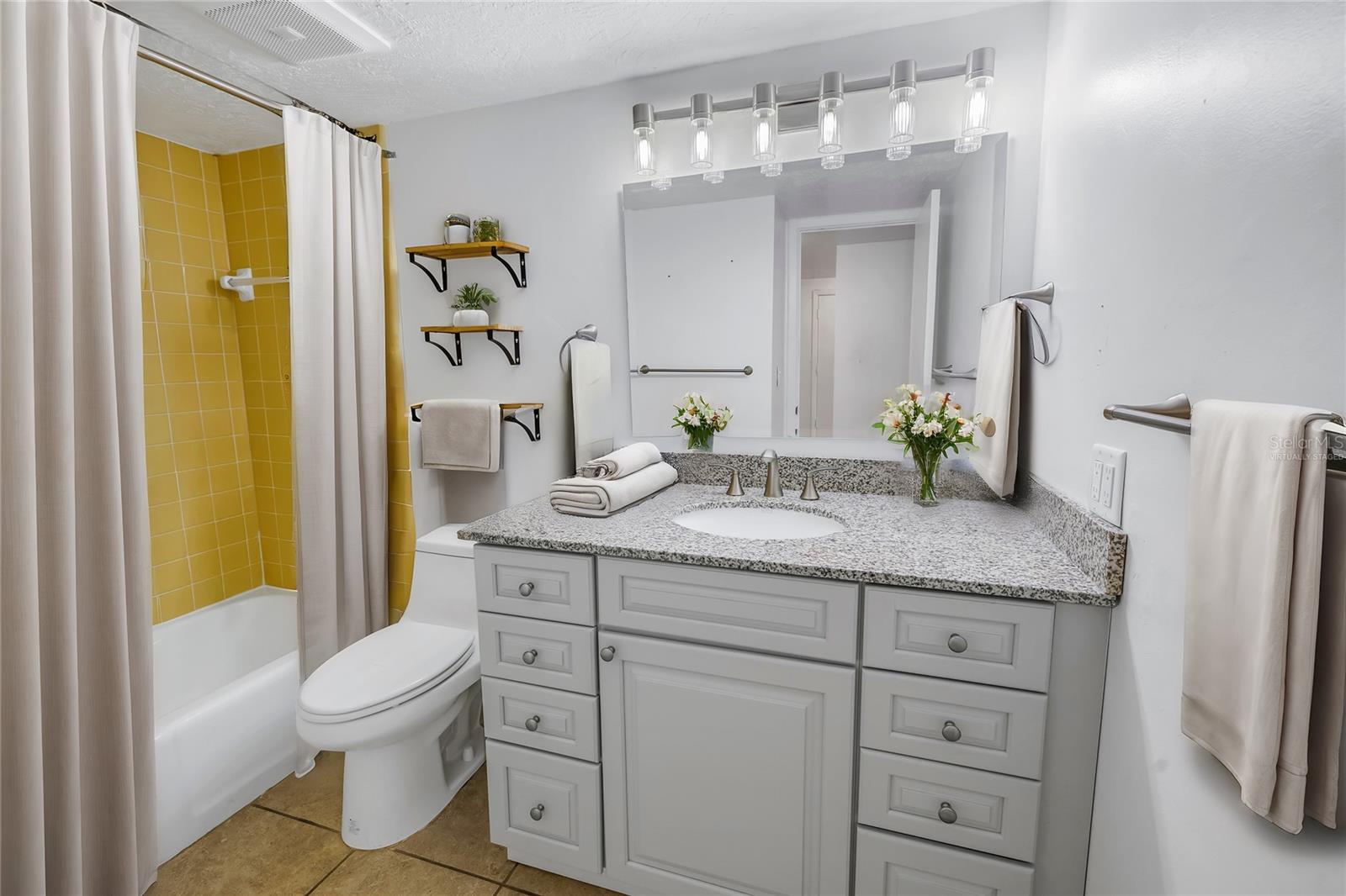 Virtually staged bathroom offers an updated vanity.