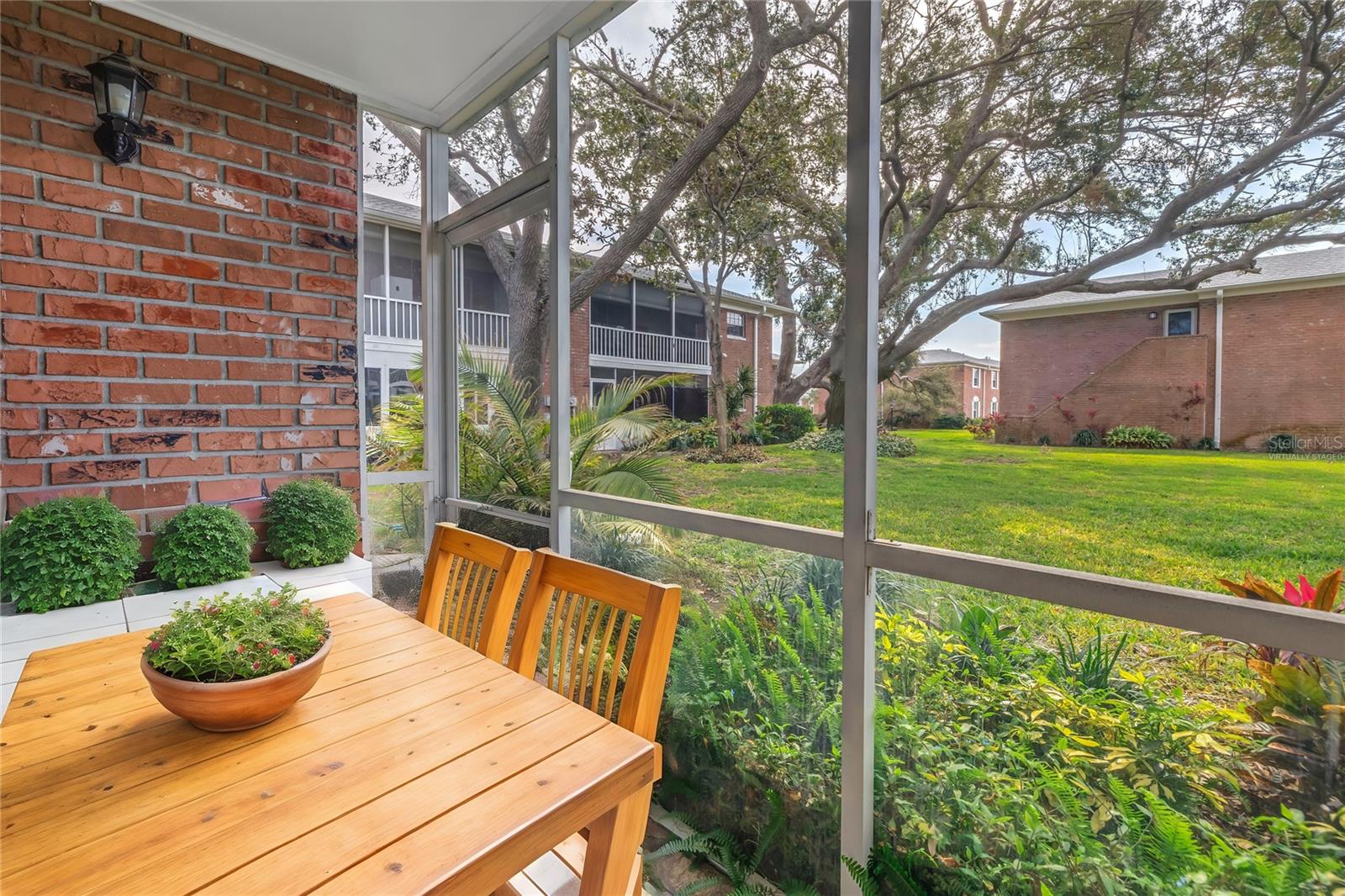 Virtually staged back screened in patio with courtyard views.