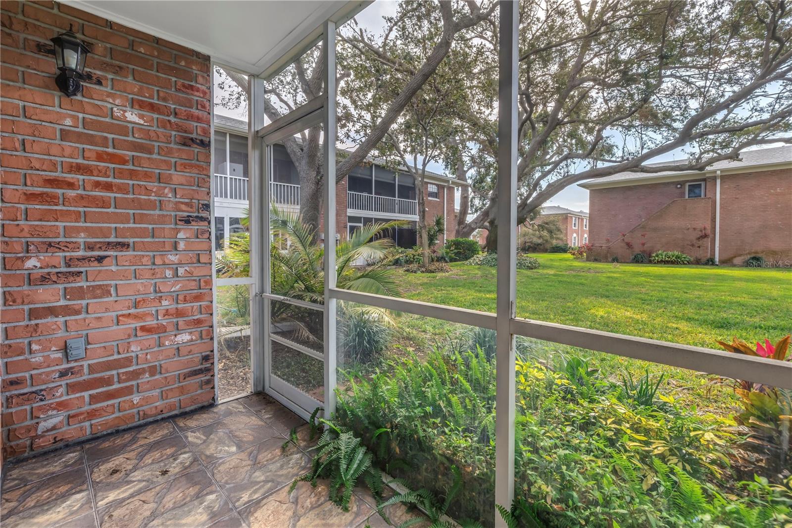 Back screened in patio with courtyard views.