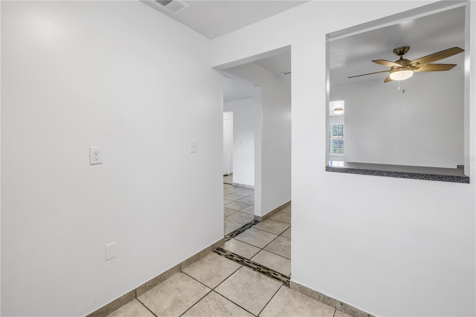 Kitchen leading to the dining room featuring a pass-through window.