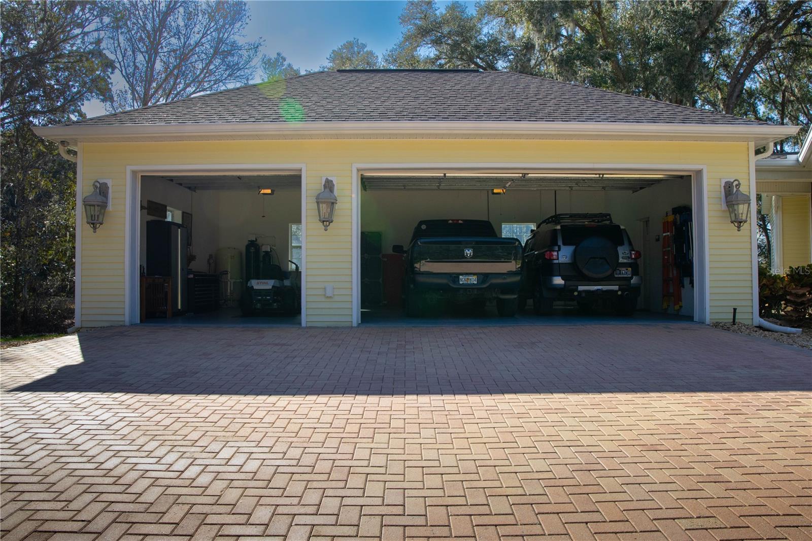 3 car oversized garage open with vehicles inside