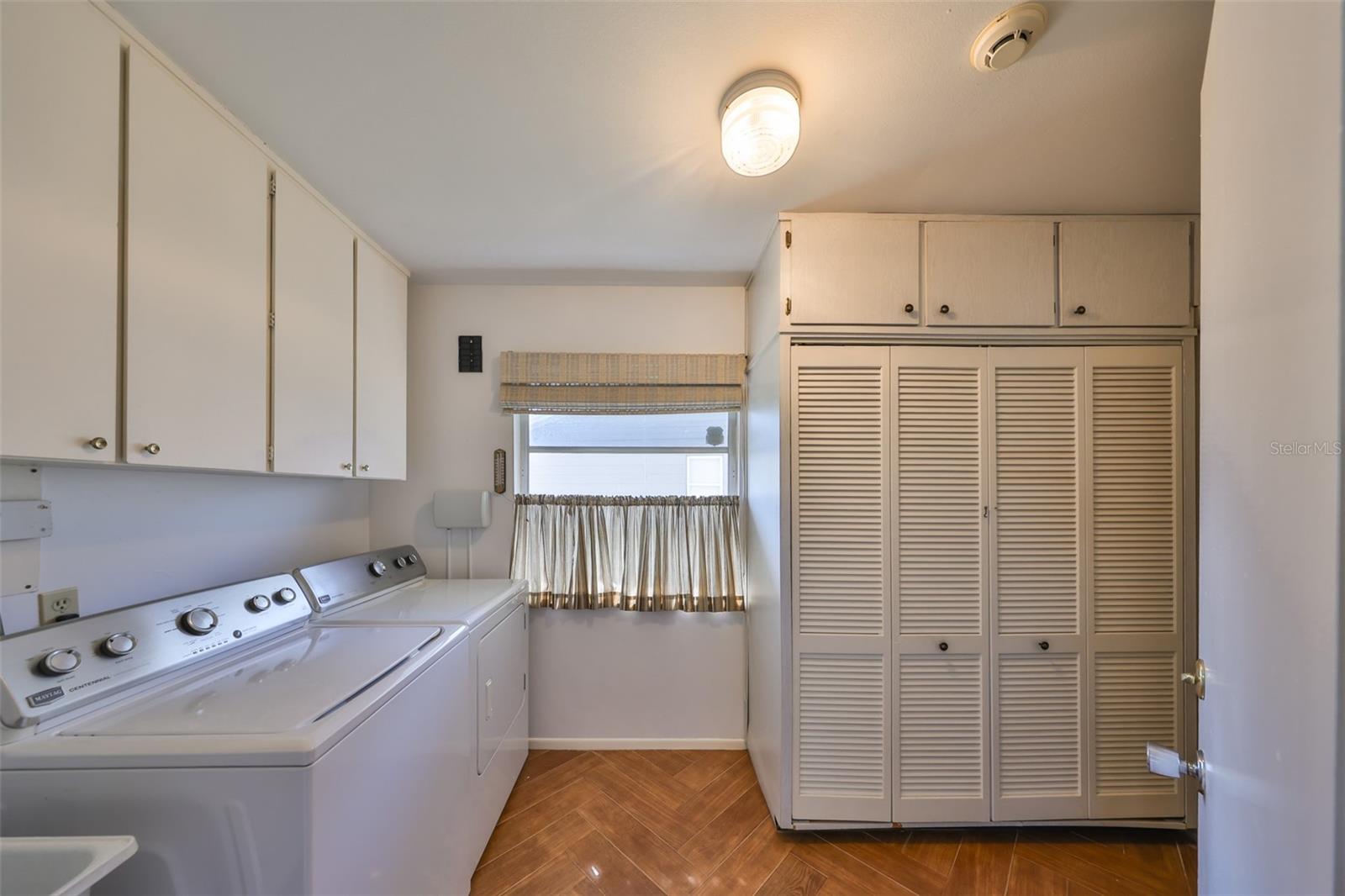 Spacious laundry off of the kitchen with loads of storage.