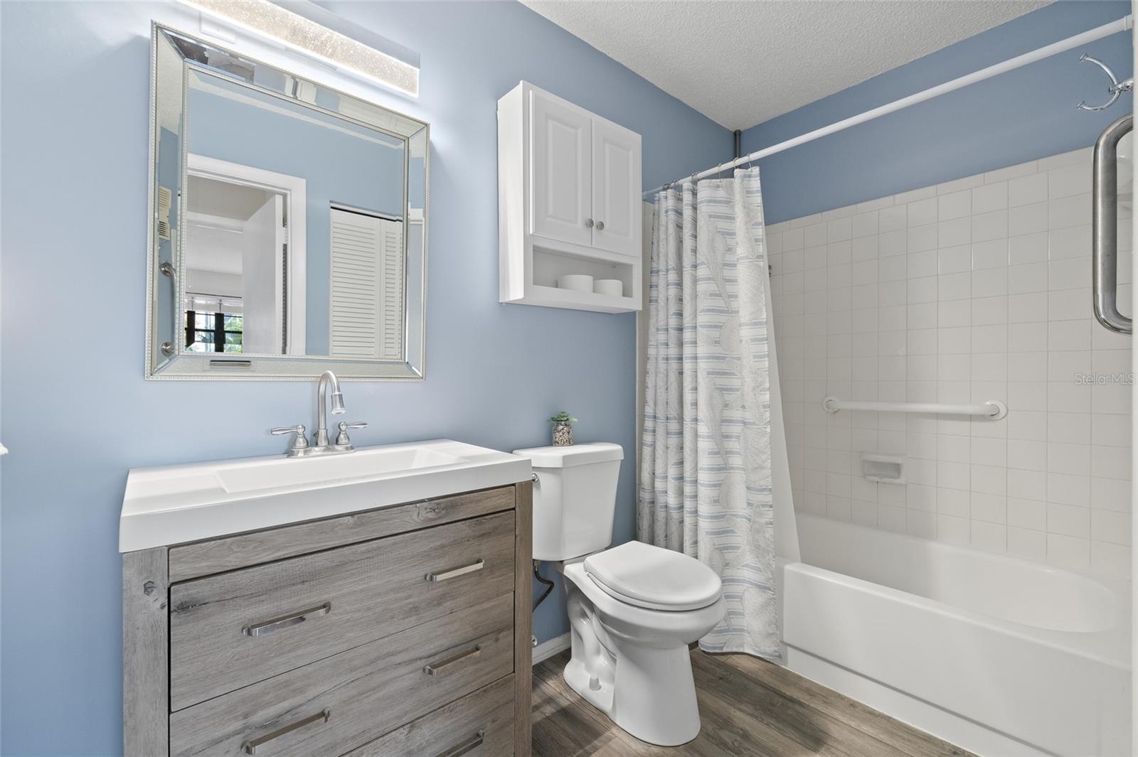 Full size bathroom with bath and tub combination.