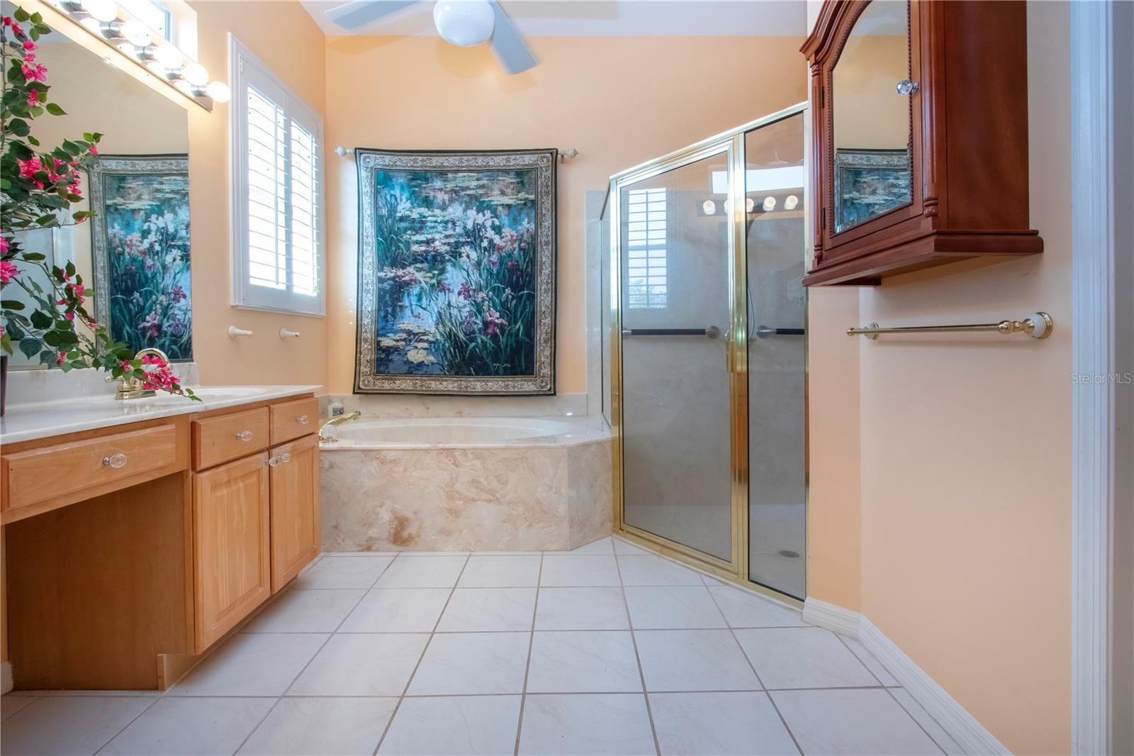 Primary Bathroom with dual sinks a soaking tub and stand up shower