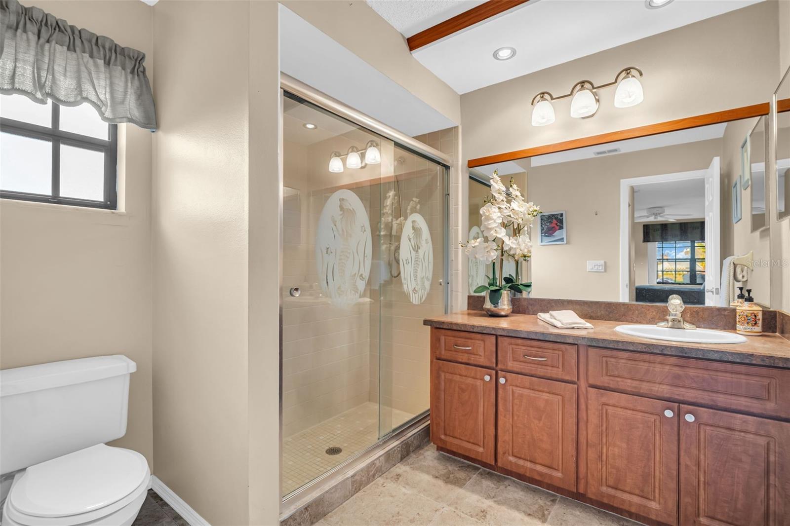 Updated en-suite with oversized vanity, newer lighting, and walk-in shower~