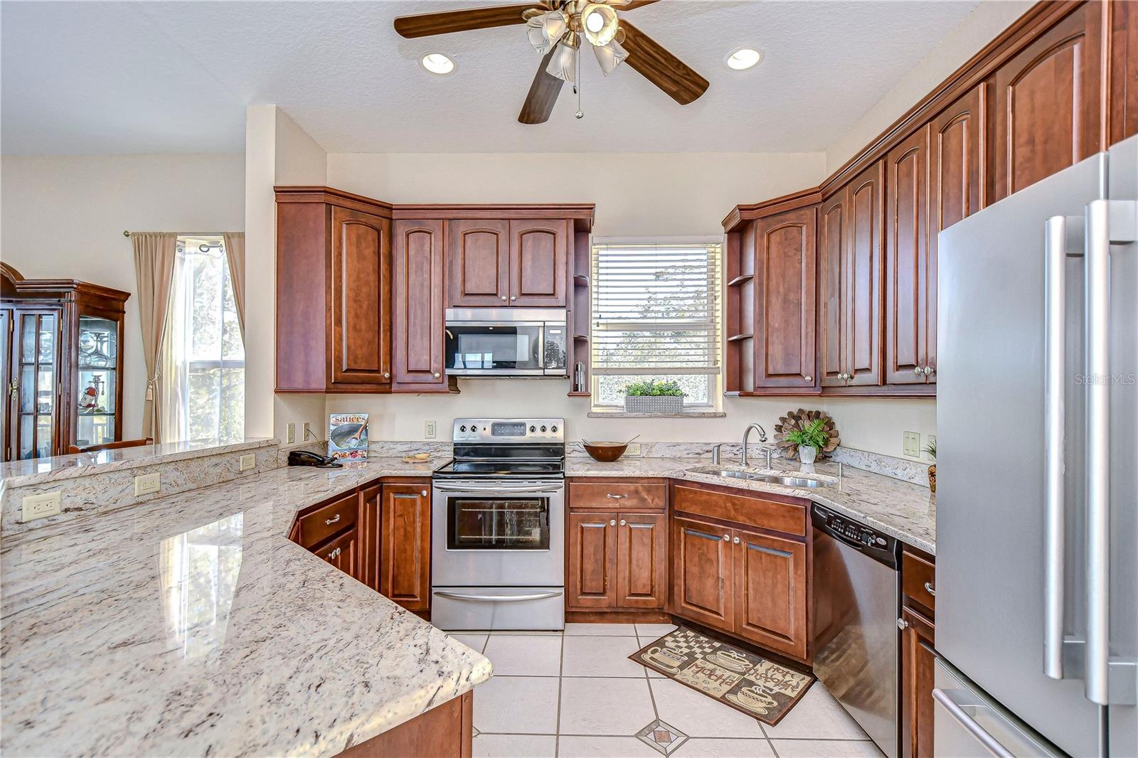 BEAUTIFUL CHERRYWOOD CABINETS AND SHIVIKASHI GRANITE COUNTERTOPS COMPLEMENT THE STAINLESS STEEL APPLIANCES.