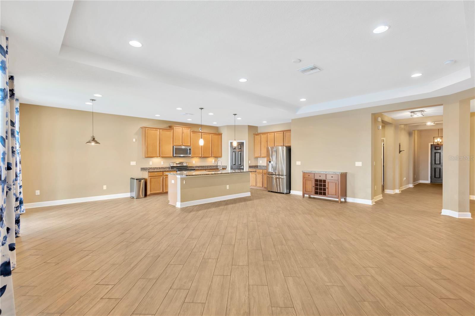 The expansive great room is designed with a large tray ceiling.  The storage cabinet next to the refrigerator is available for a new owner.