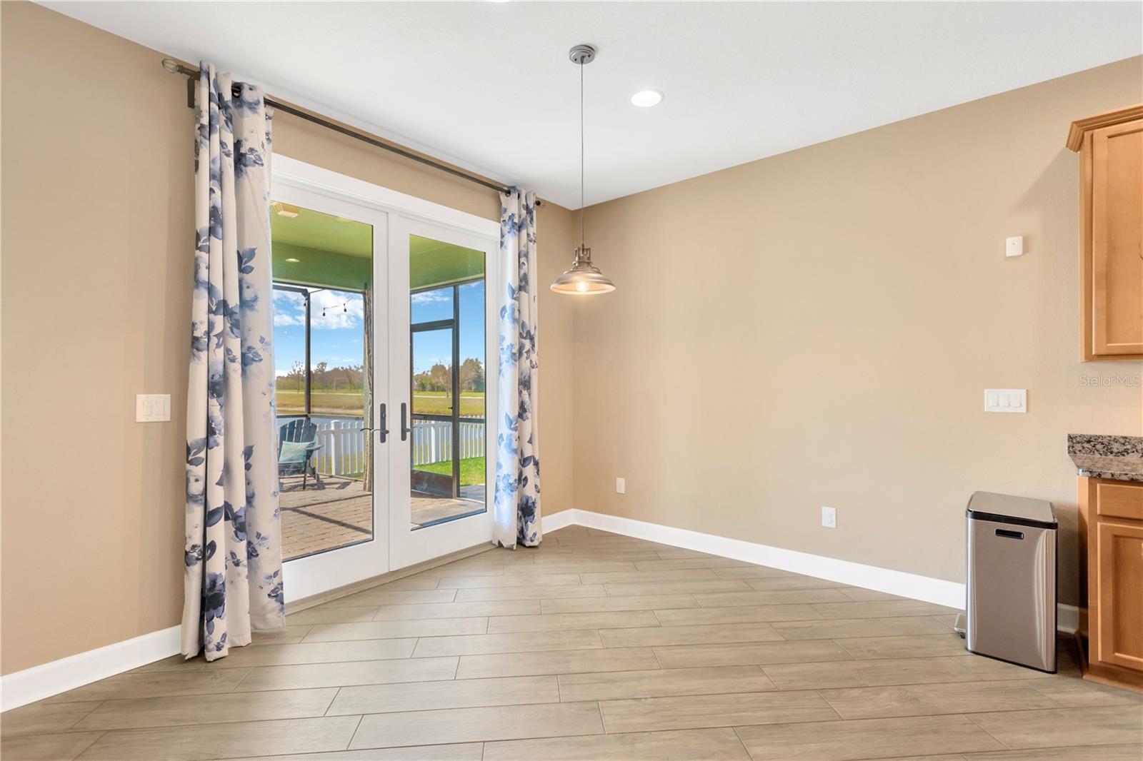 Stunning glass french doors leads from dining area next to the kitchen to your backyard oasis.  Hurricane impact windows throughout this home and french door were installed in (2023).