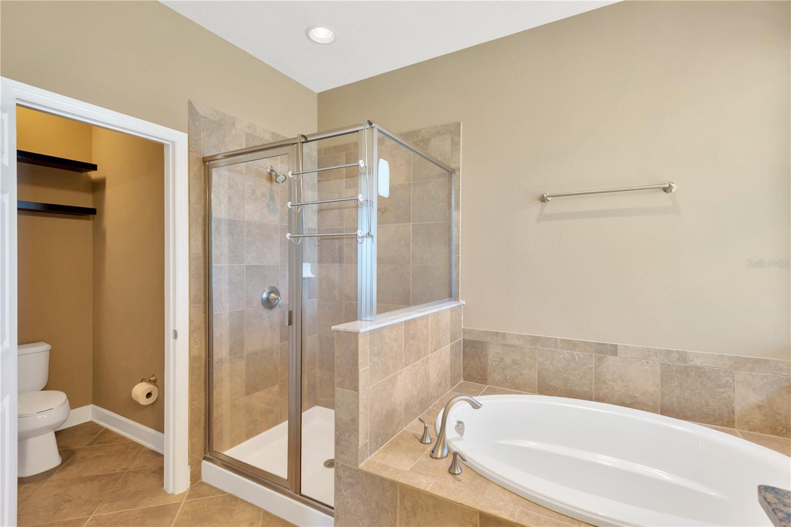 The en suite bathroom has a separate shower, a relaxing soaker tub, and a private water closet.