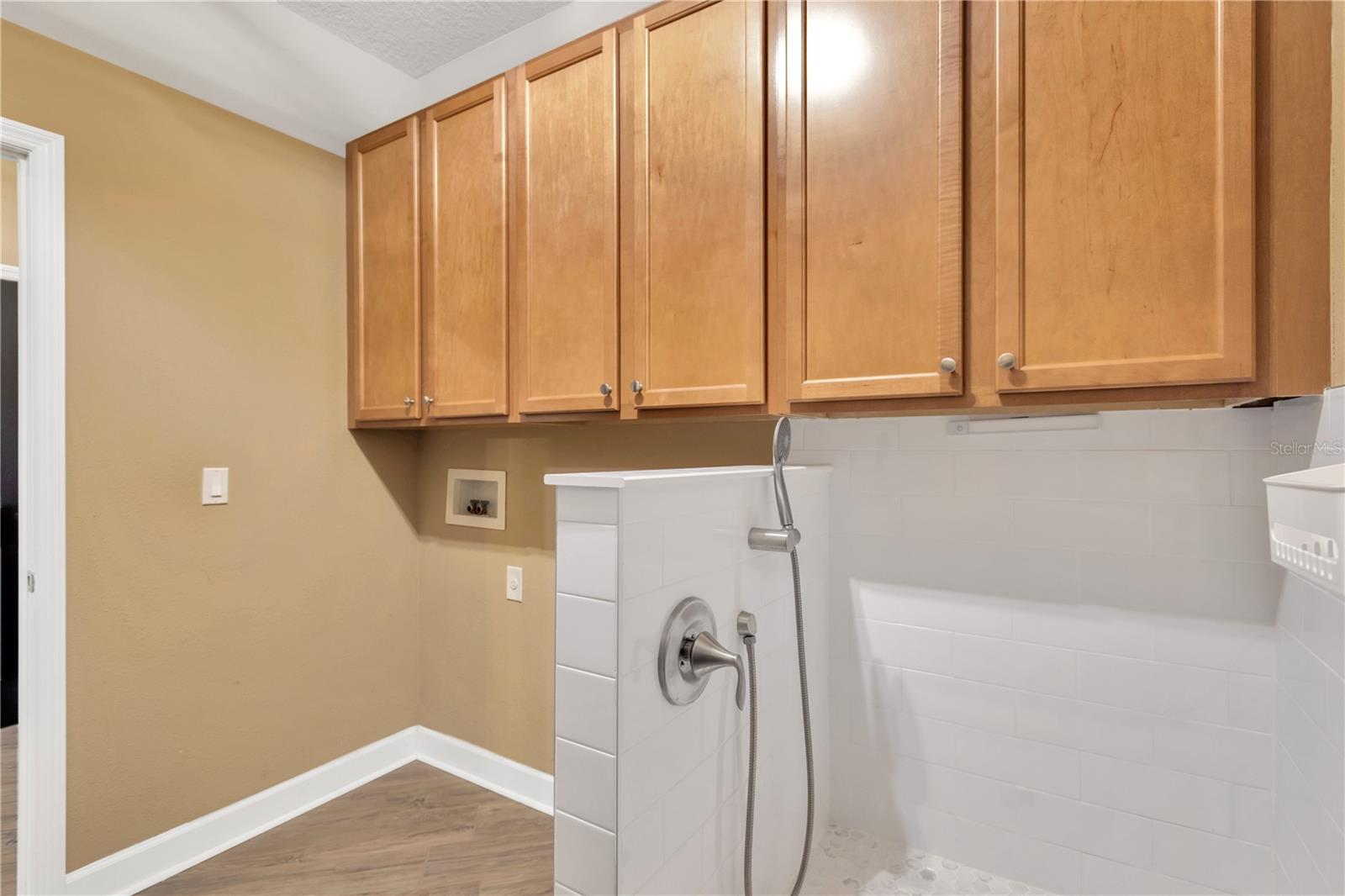 The Laundry room has an awesome step-in dog shower installed along with several additional storage cabinets.  Washer and electric dryer should be supplied by new owners.