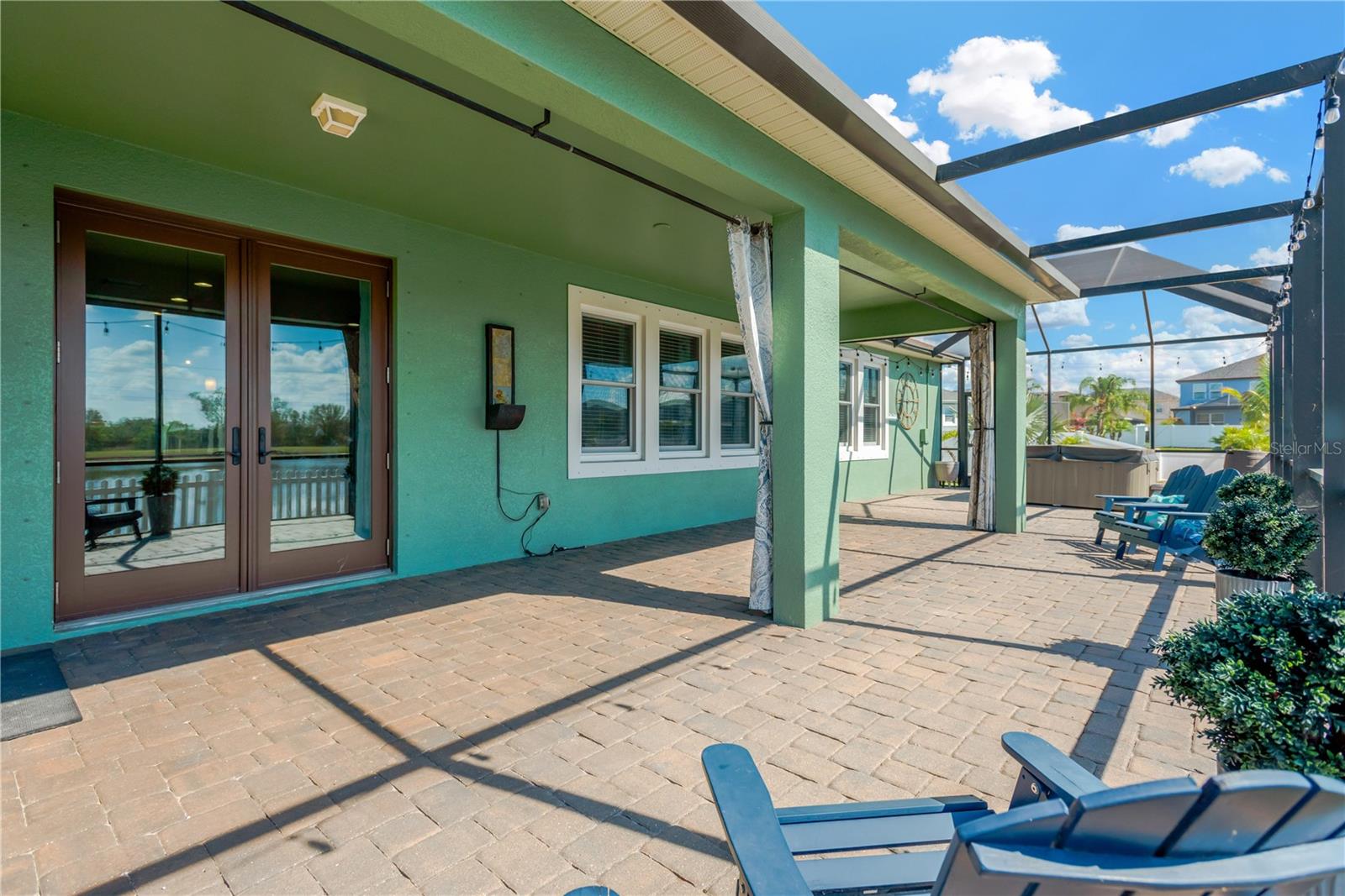 Access from Kitchen eat-in area to lanai.  The wall fountain next to the French doors, along with the Adirondack chairs on the lanai, will convey to the buyer.