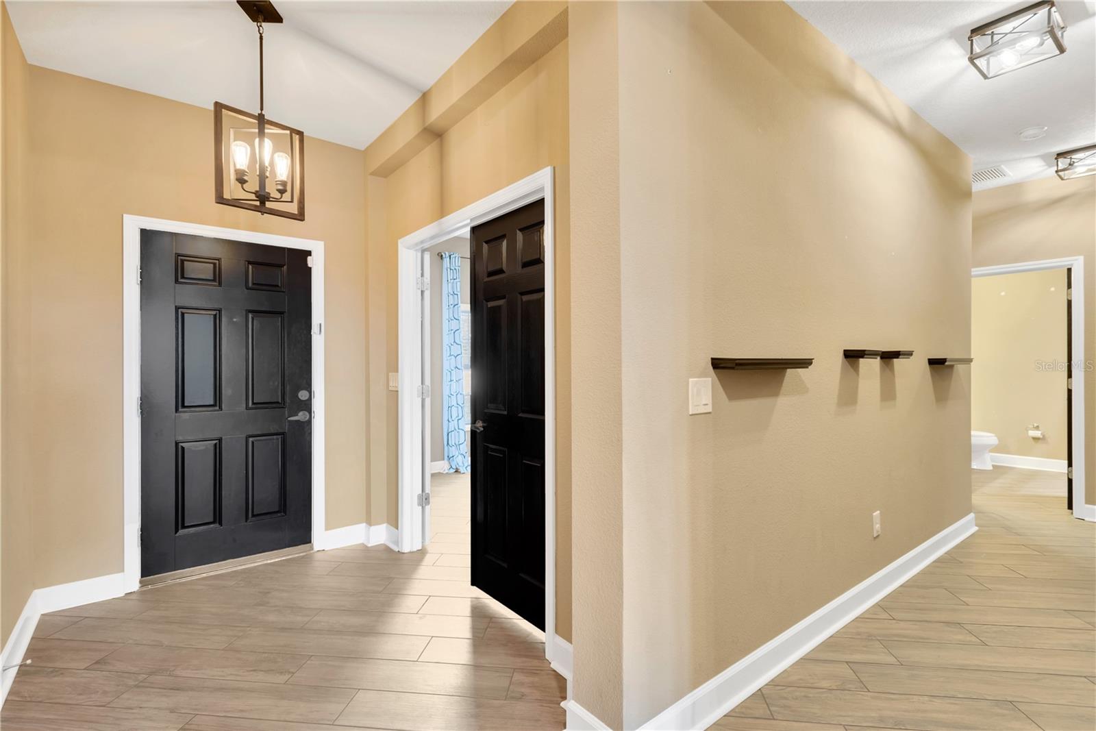 As you step inside, you'll be greeted by soaring ceilings with elegant tray details and newly installed matte porcelain wood-look tile flooring.  The 4th bedroom or office  (no closet) is to your left behind double doors.