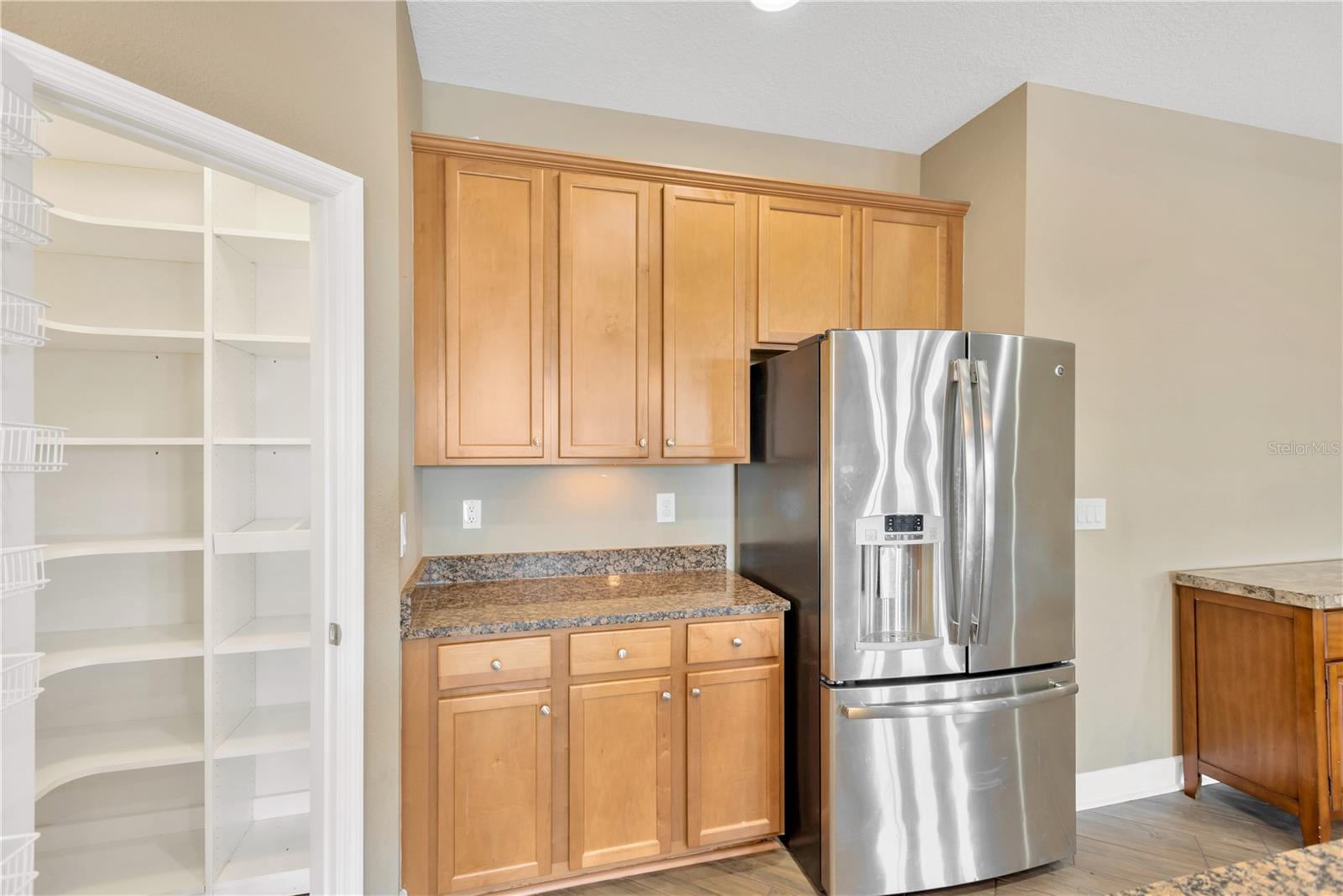 The kitchen is enhanced with stainless steel appliances including a range with a double oven and a corner walk-in pantry with customer shelving to keep you organized.