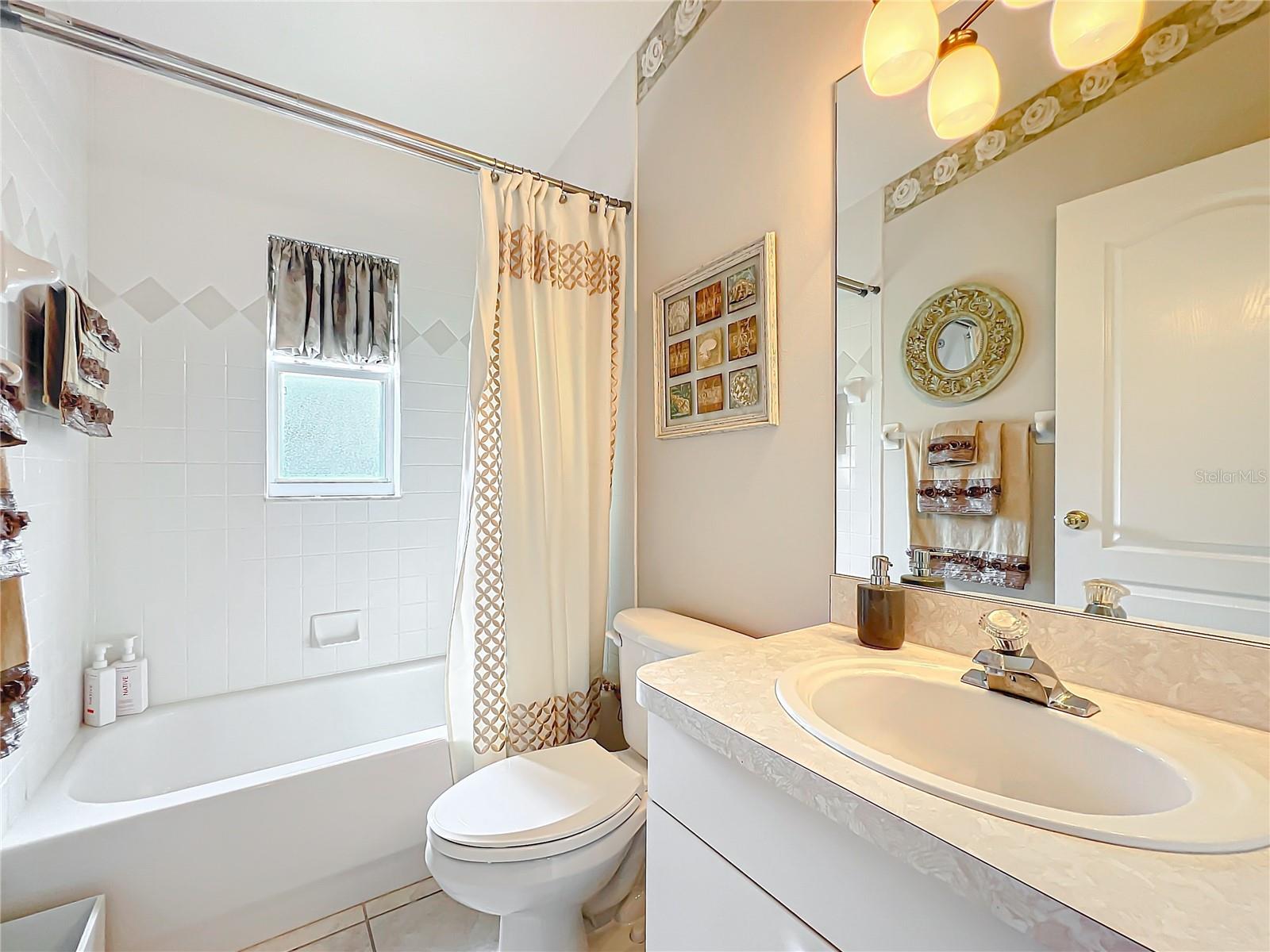 Bathroom 2 is a tub / shower combination with a frosted window for privacy. Updated lighting.