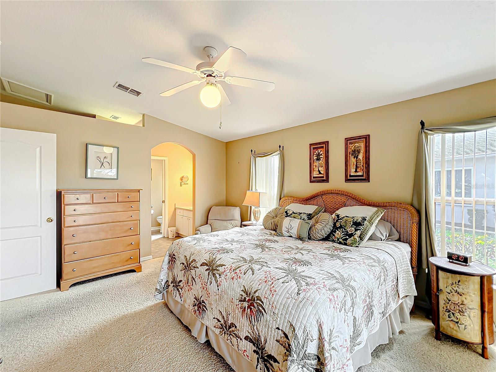 Primary bedroom with arched opening into the primary bathroom.