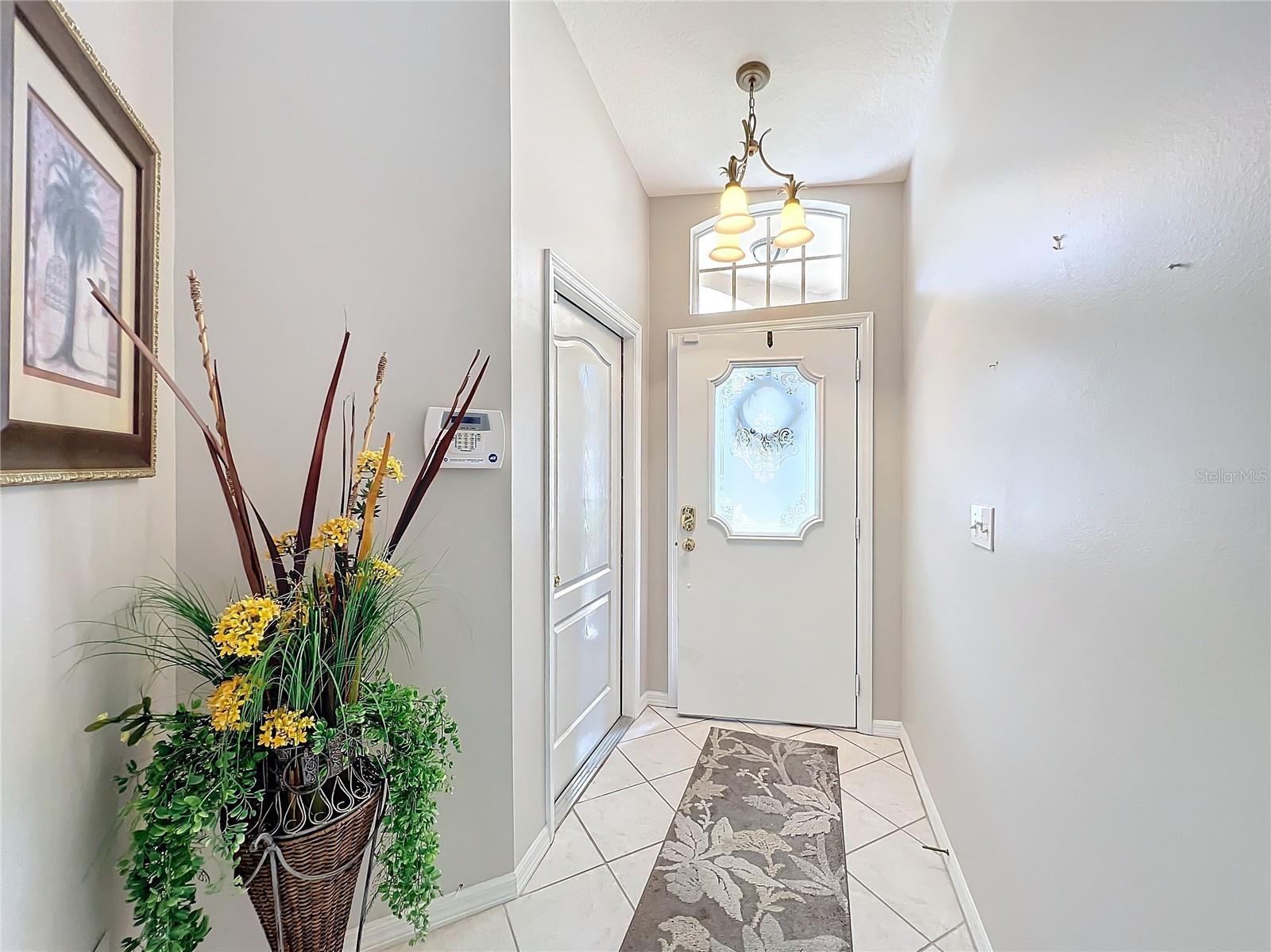 The foyer is very bright with the extra window above the door. The door to the left in this picture leads out to the 2 car garage .