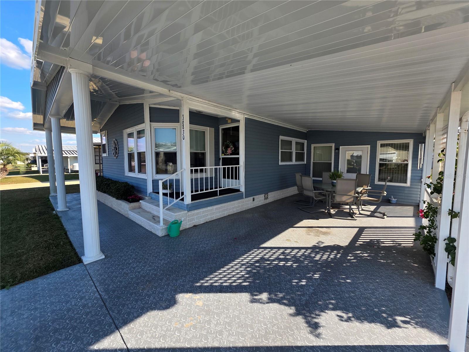 Painted driveway. Carport, covered front sidewalk, main entry.