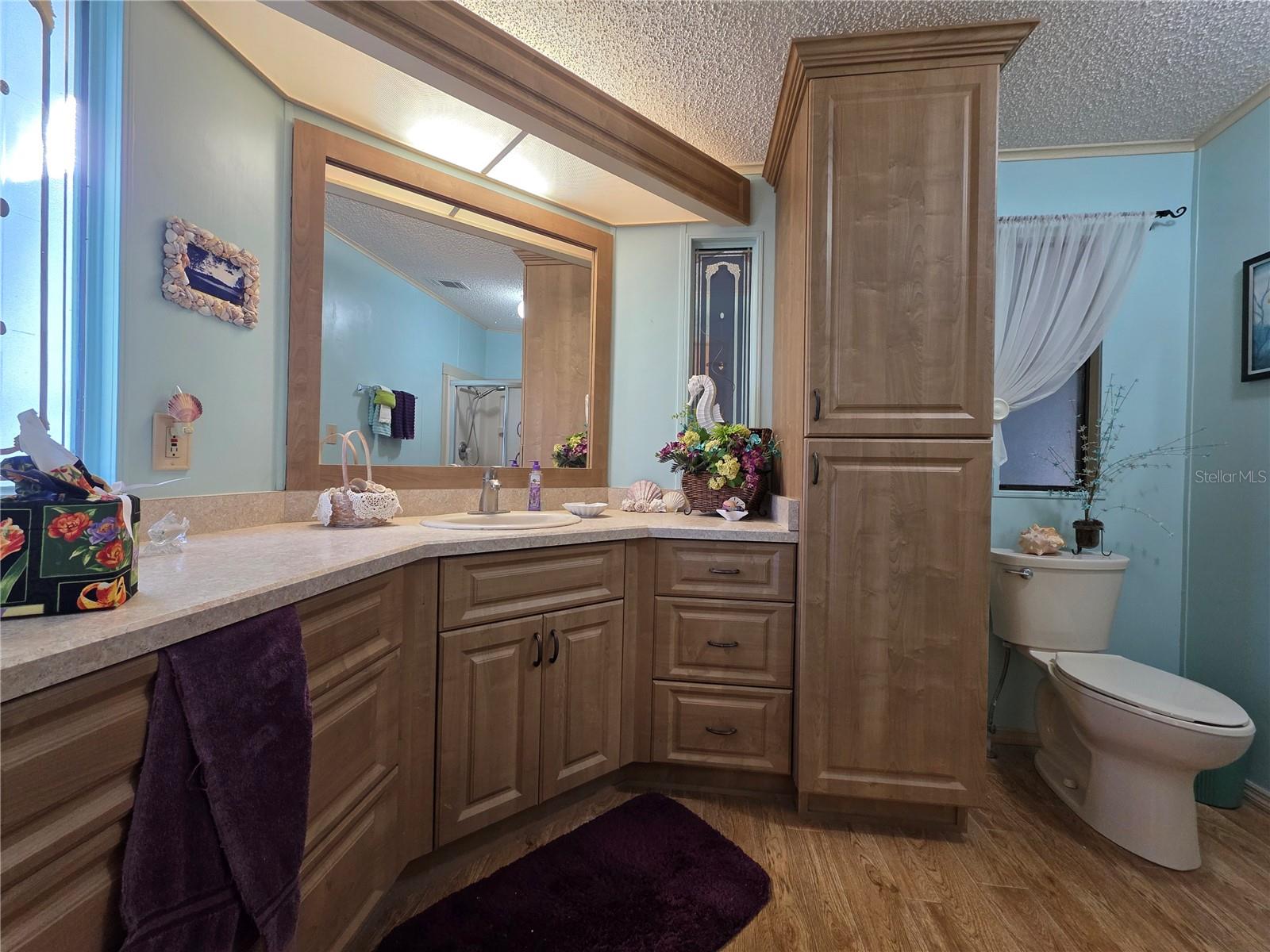 En-suite bathroom with walk-in shower & linen cabinet.