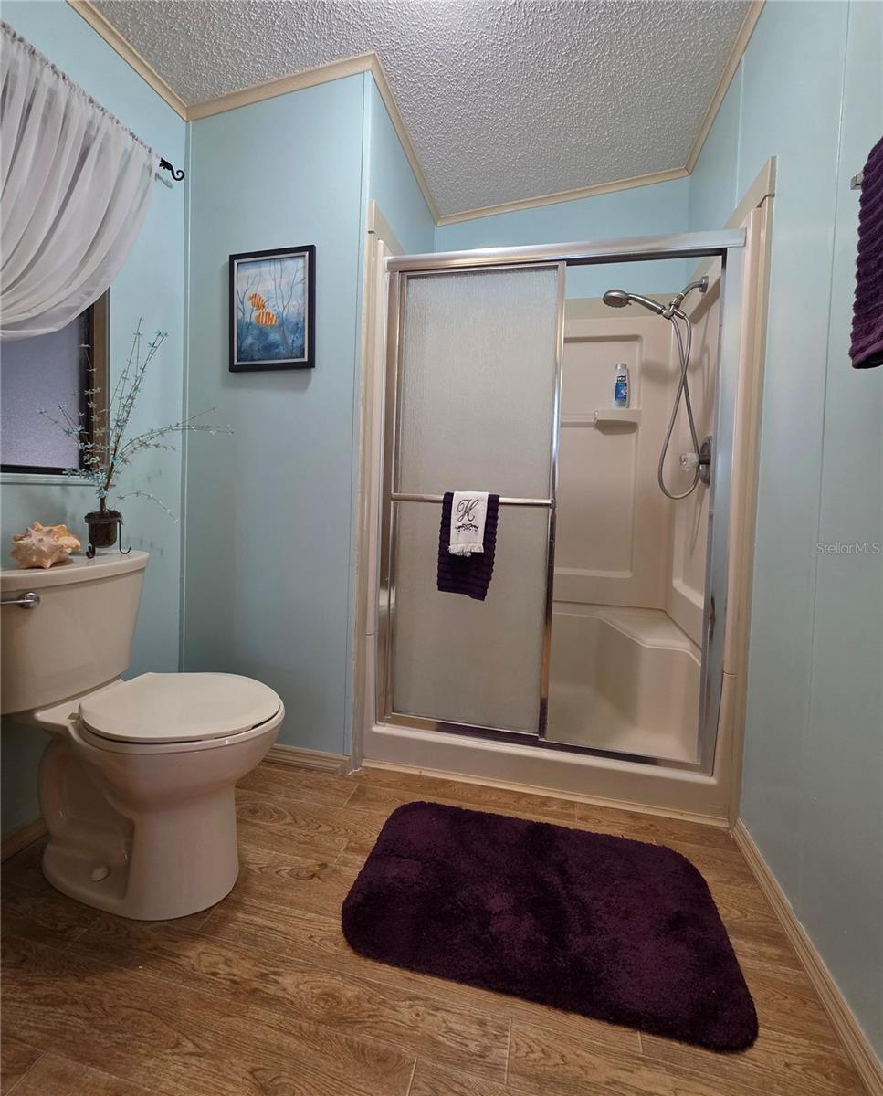 En-suite bathroom with walk-in shower & linen cabinet.