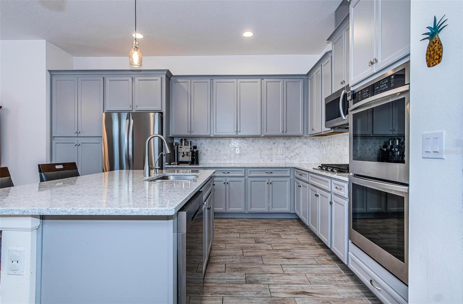 Lots of storage space in this open kitchen! Stainless steel appliances include a double oven.