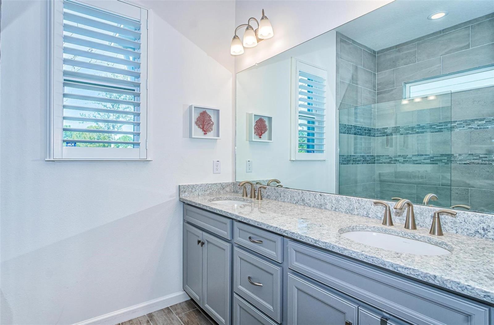The Main bedroom has a large bathroom with double sinks and granite countertop.