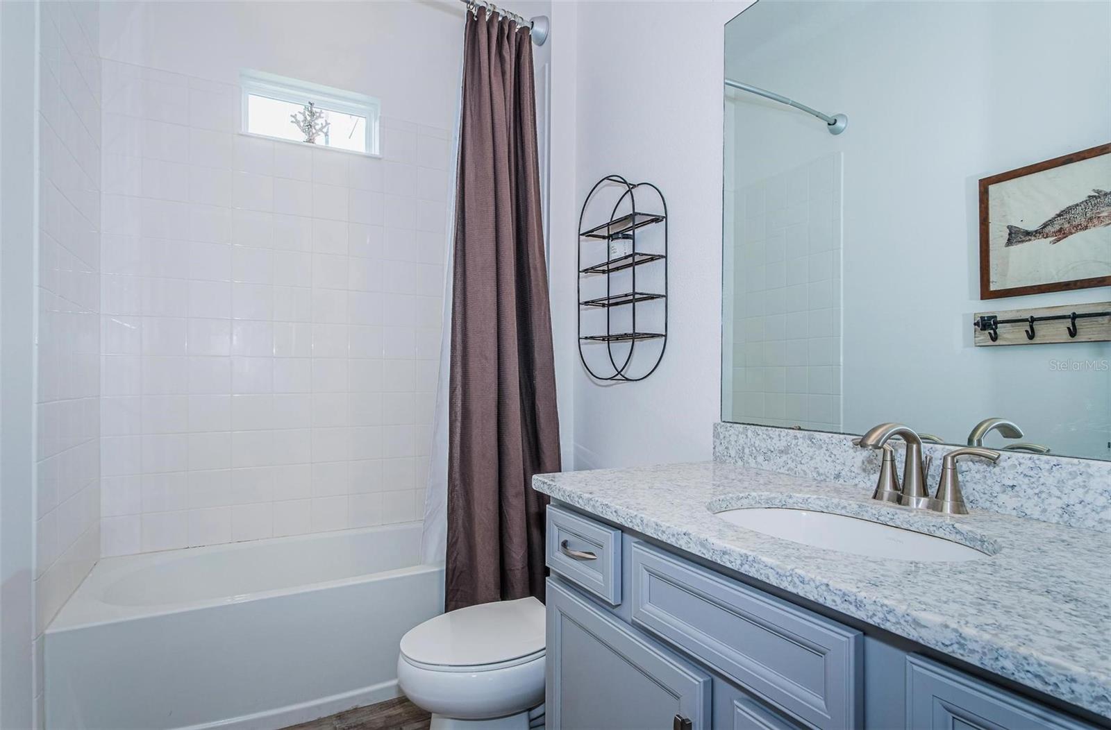 Clean and bright 2nd bathroom with granite counter tops is located between bedroom 2 & bedroom 3.