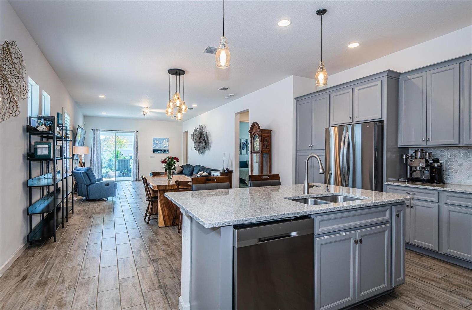 Gorgeous gray cabinets with granite countertop and decorative tile backsplash.
