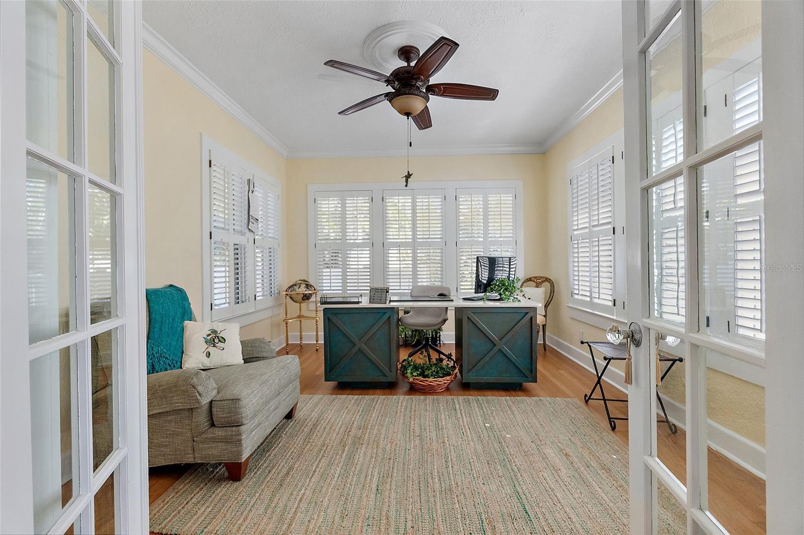 Current light and bright office with French doors off living room