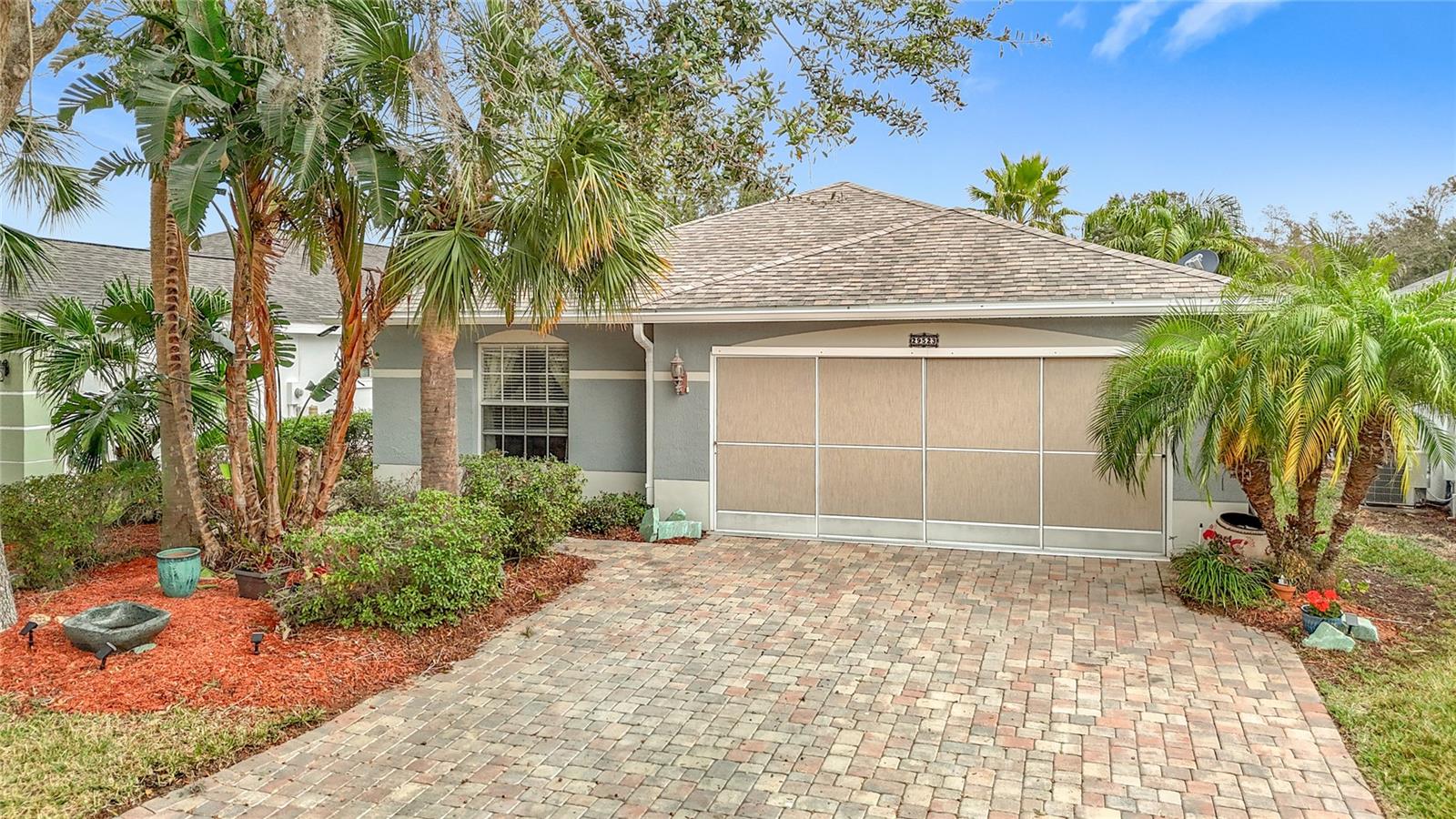 Front view of the home with beautiful paver driveway and screen garage