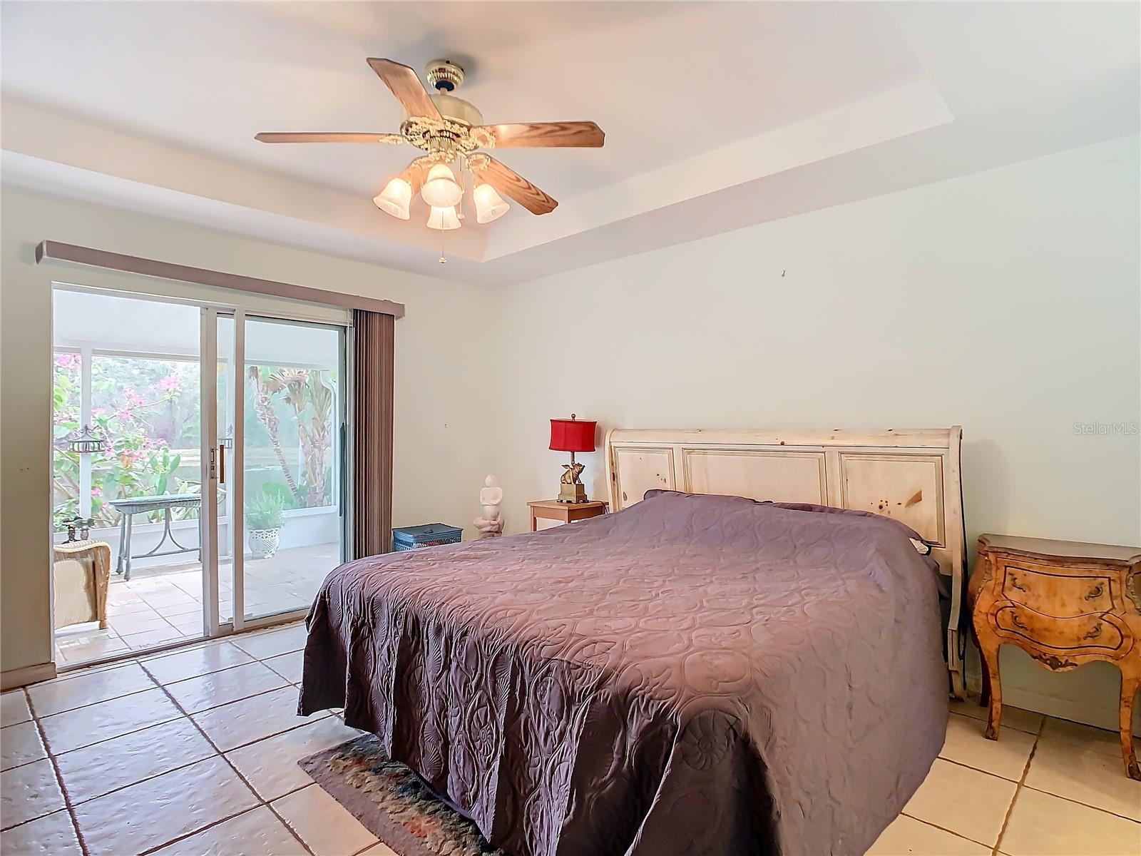 Primary bedroom with sliding door leading to the a private screened lanai