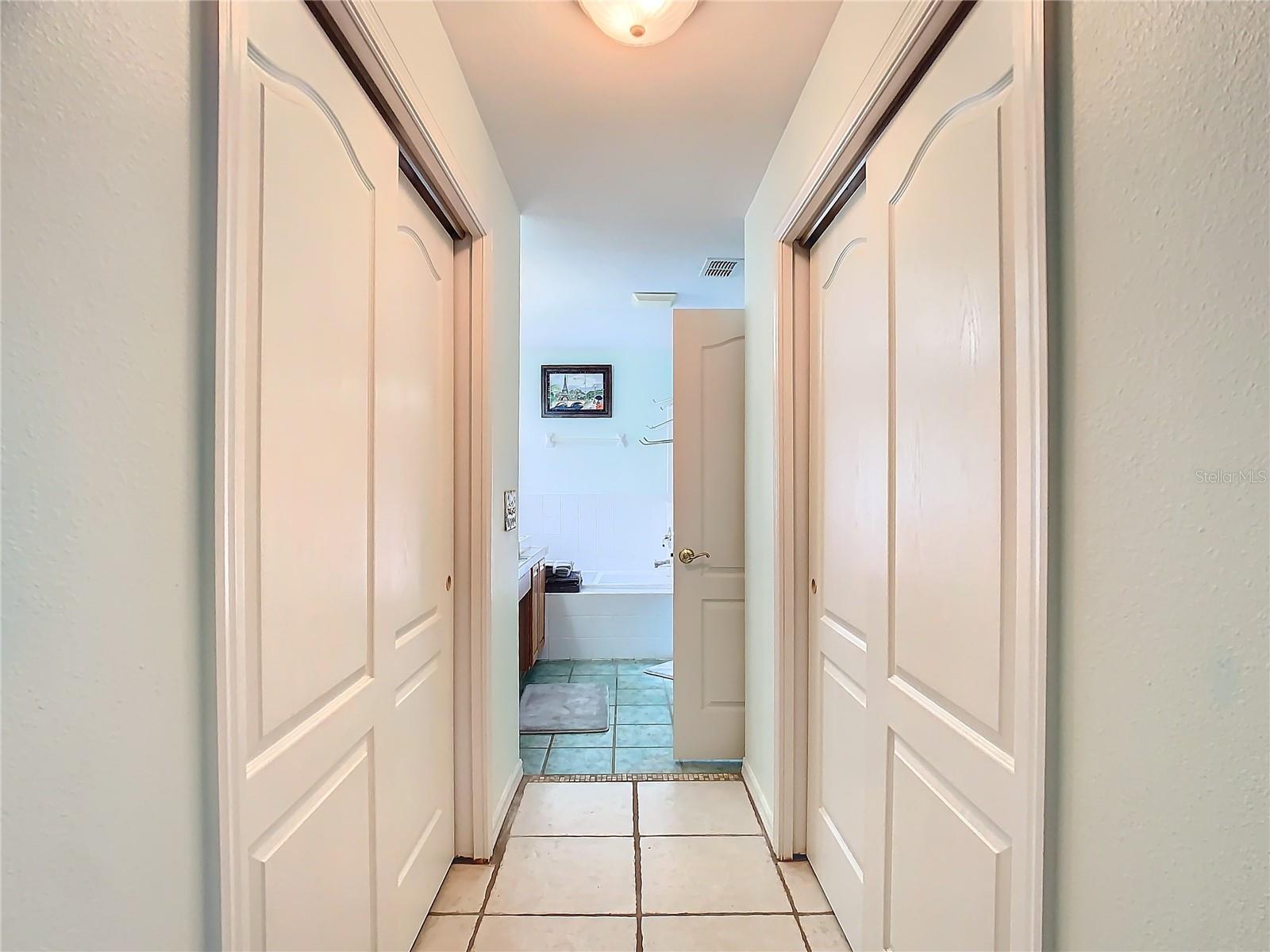 Primary bedroom with double closets leading to the en-suite bathroom