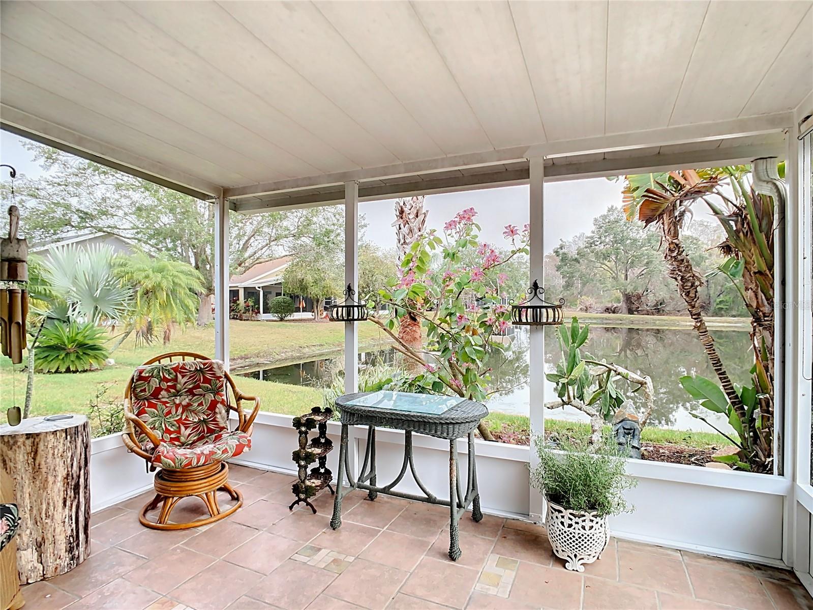 Primary private screened lanai looking over the backyard pond