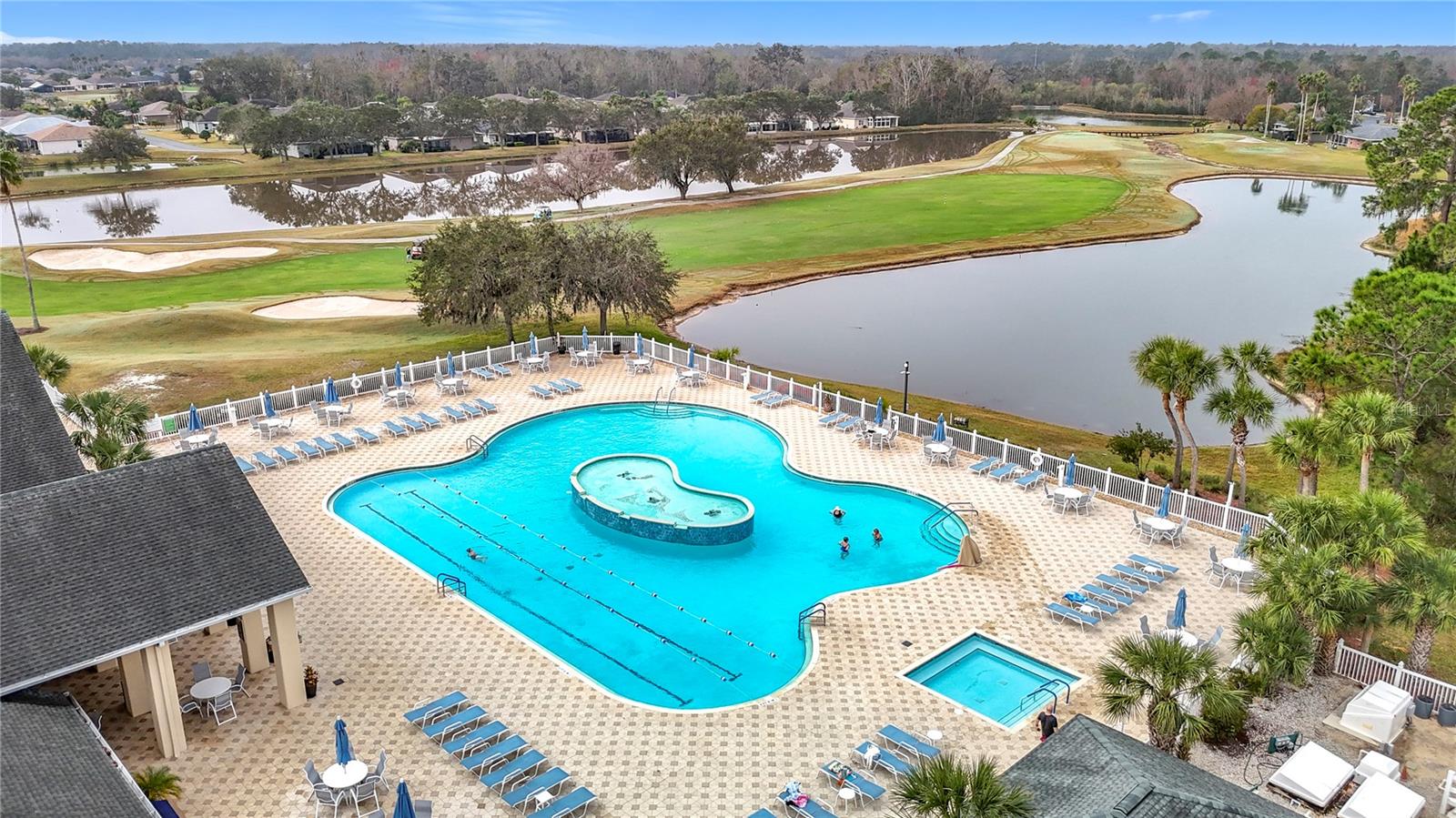 Aerial view of the main exquisite pool overlooking ponds and nearby community homes