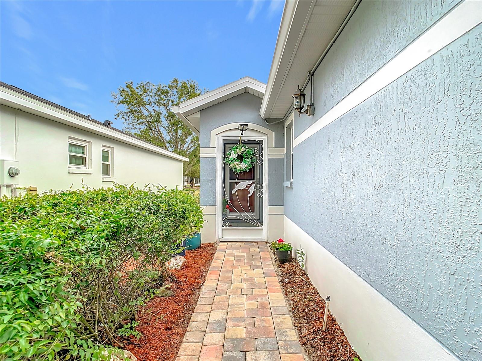 Paver walkway leading to the screened room entryway