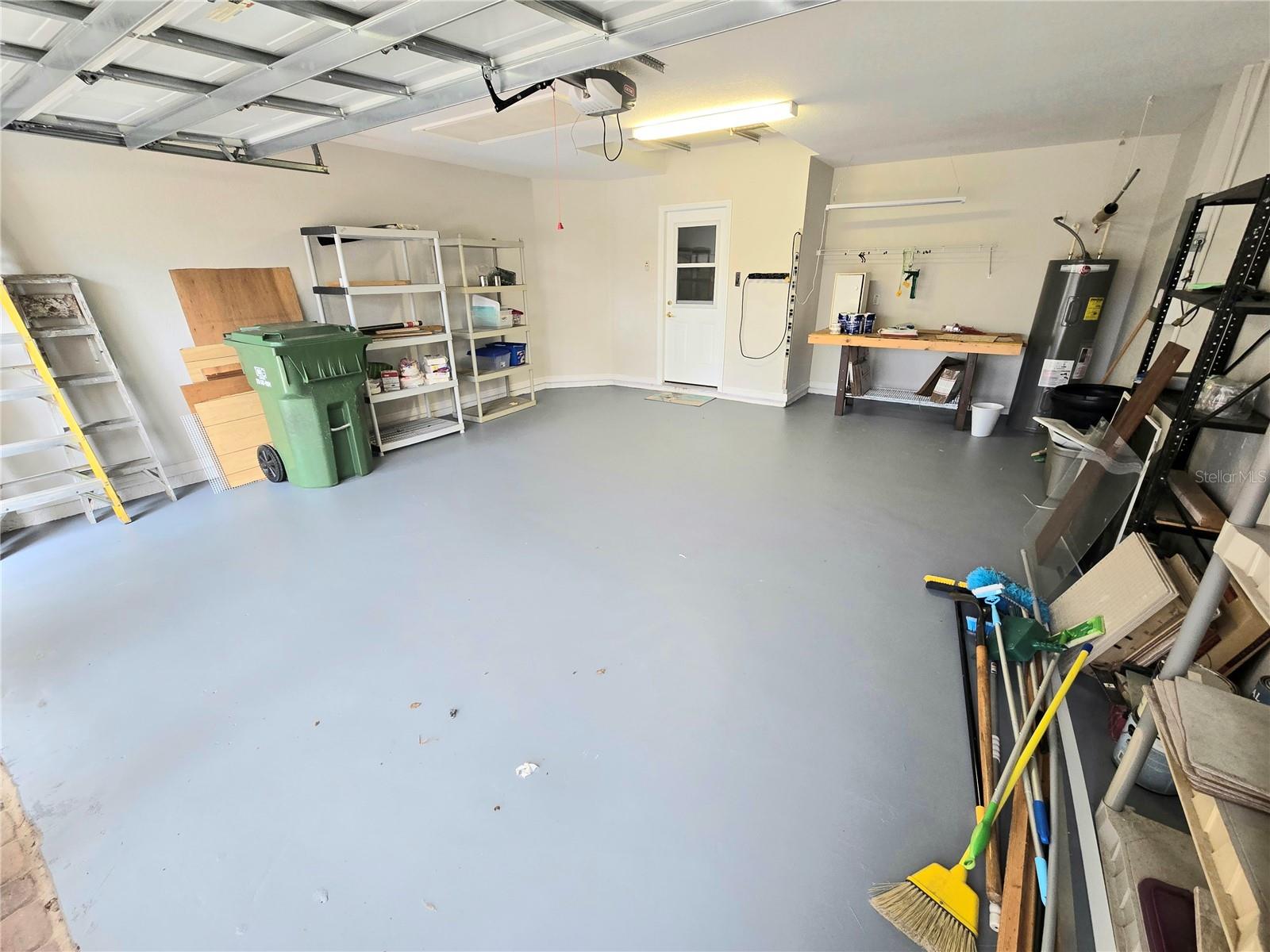 Spacious garage with screen door leading to driveway
