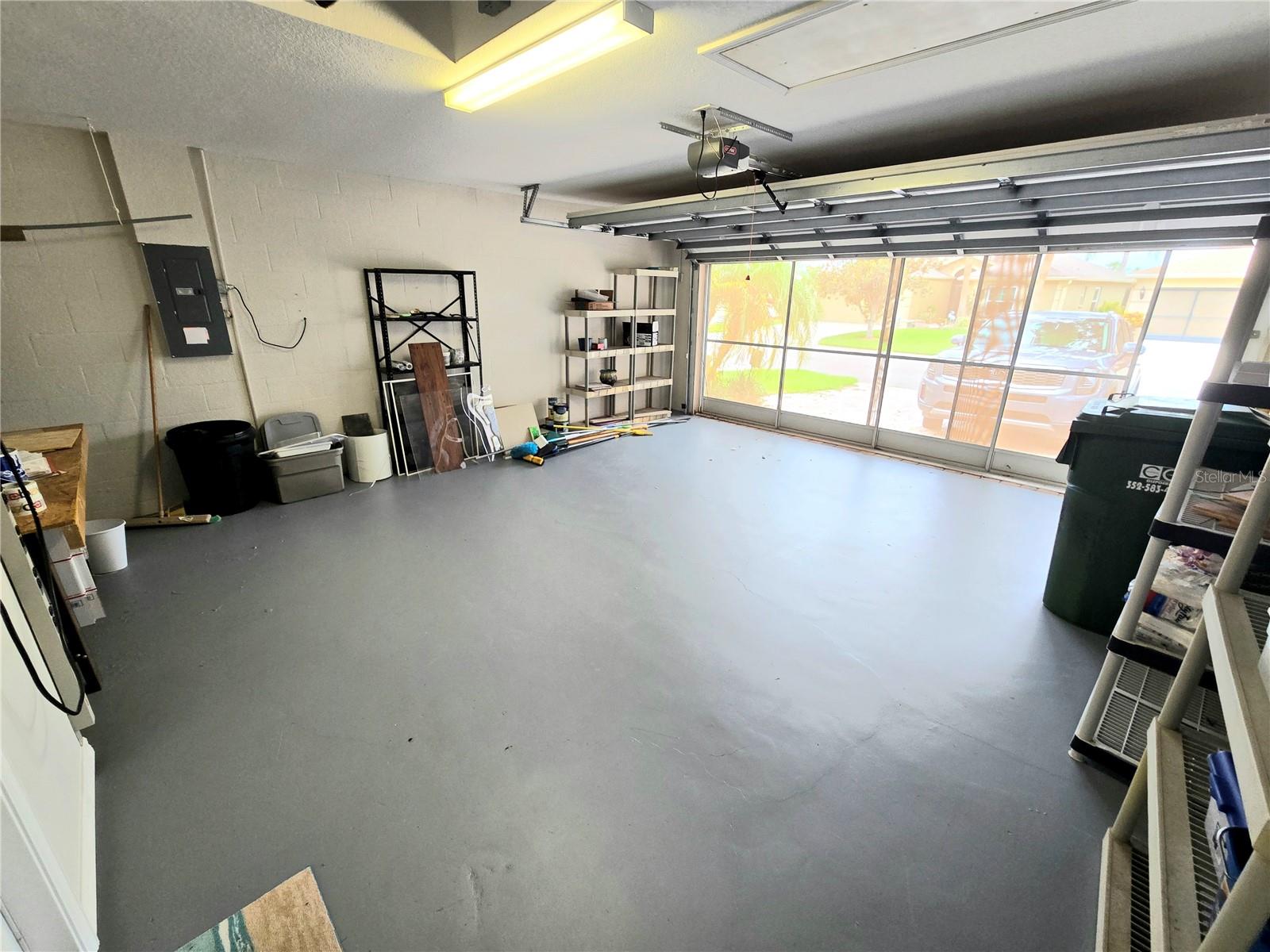 Spacious garage with screen door leading to driveway