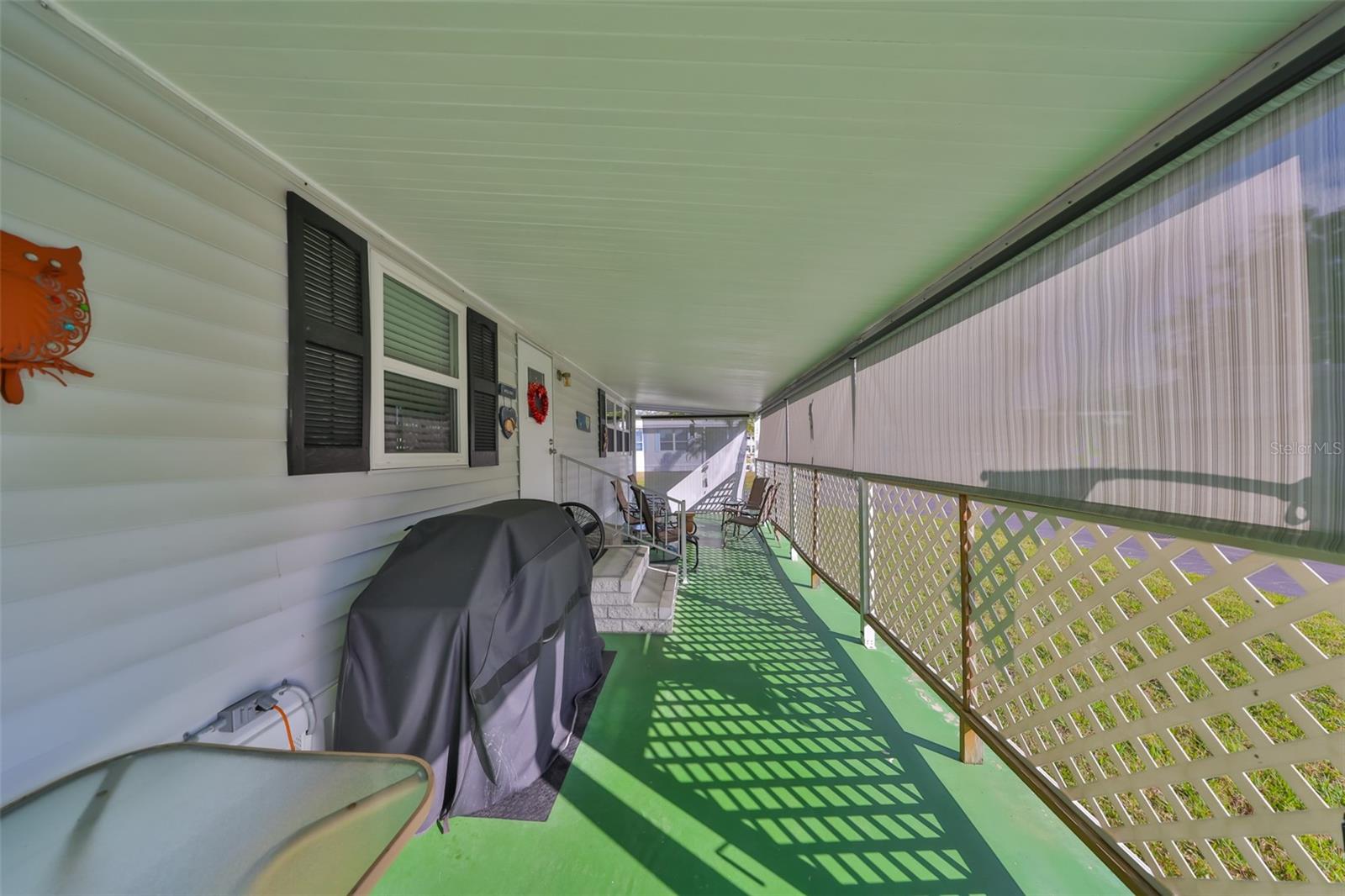 Front porch with roll-down blinds for privacy.