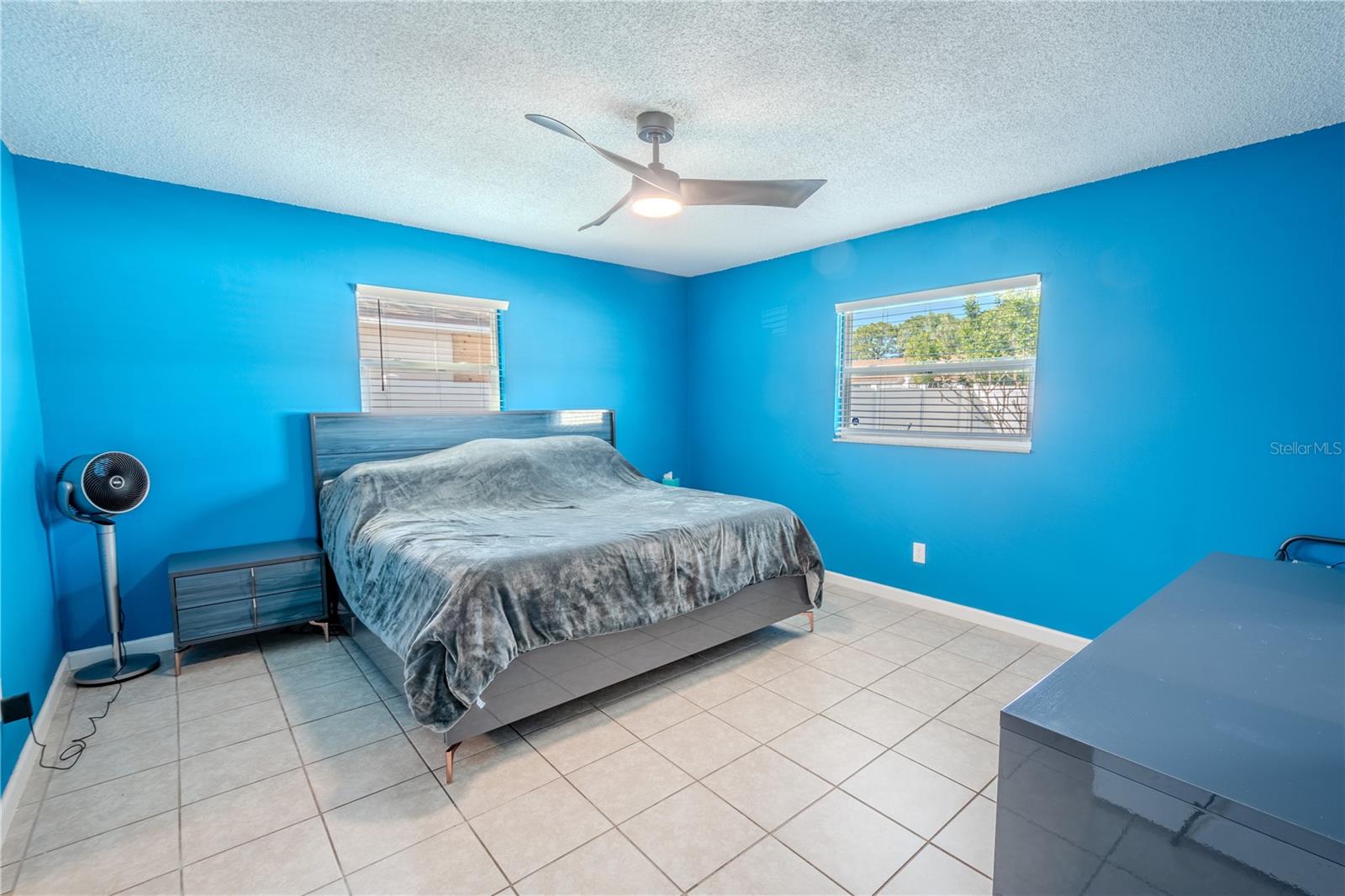 The primary bedroom features ceramic tile flooring, a ceiling modern fan with light kit, a walk-in closet and an ensuite bath.