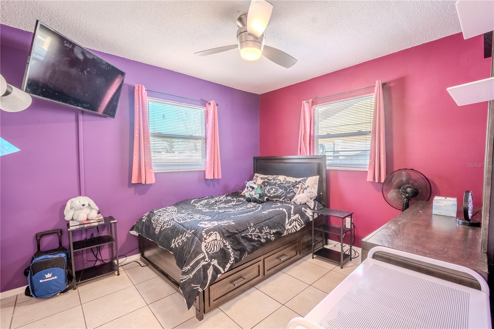 Bedroom 2 has a modern ceiling fan, tile floor and a built-in closet.