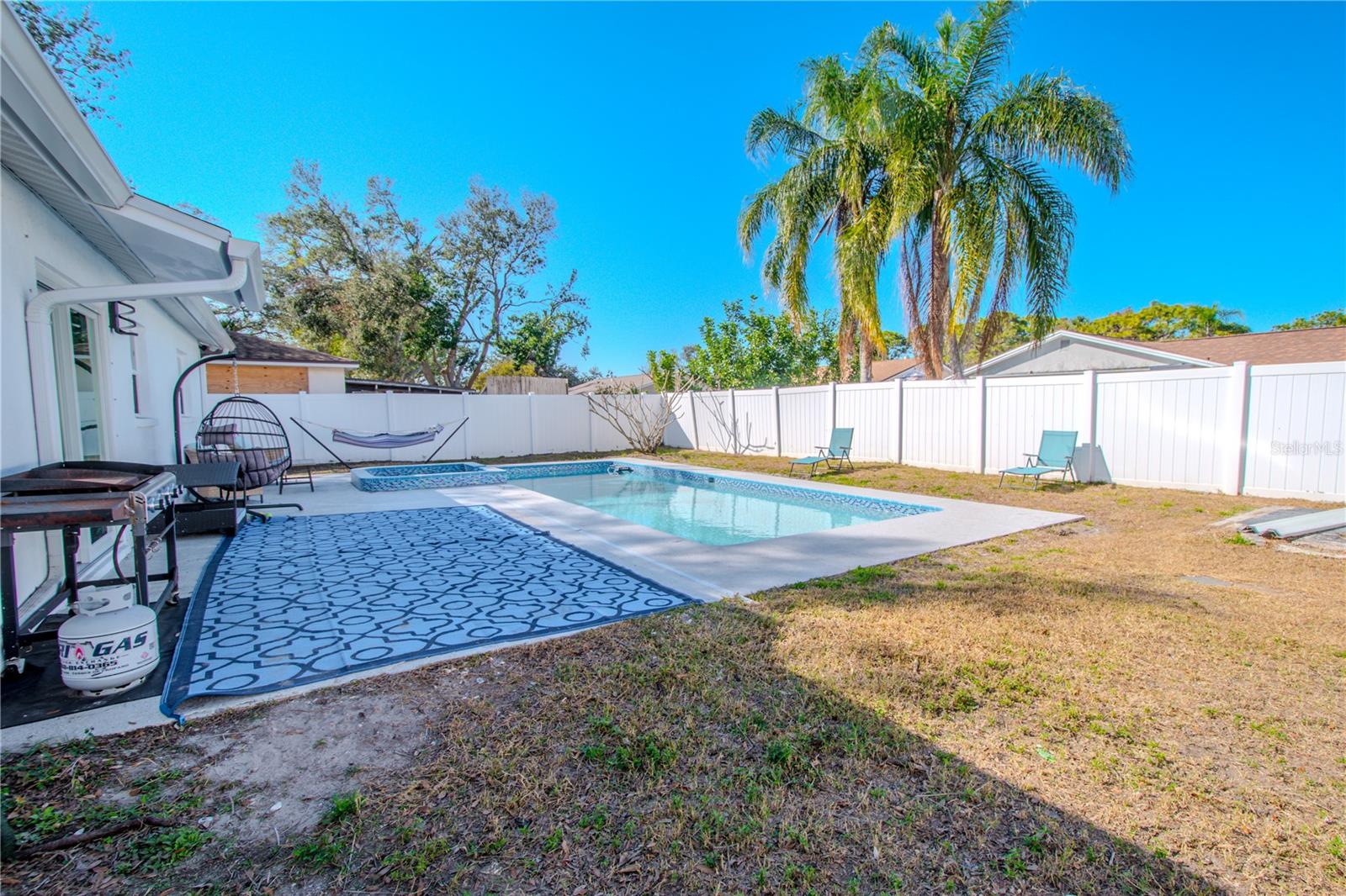 The backyard is kept private with a vinyl fence