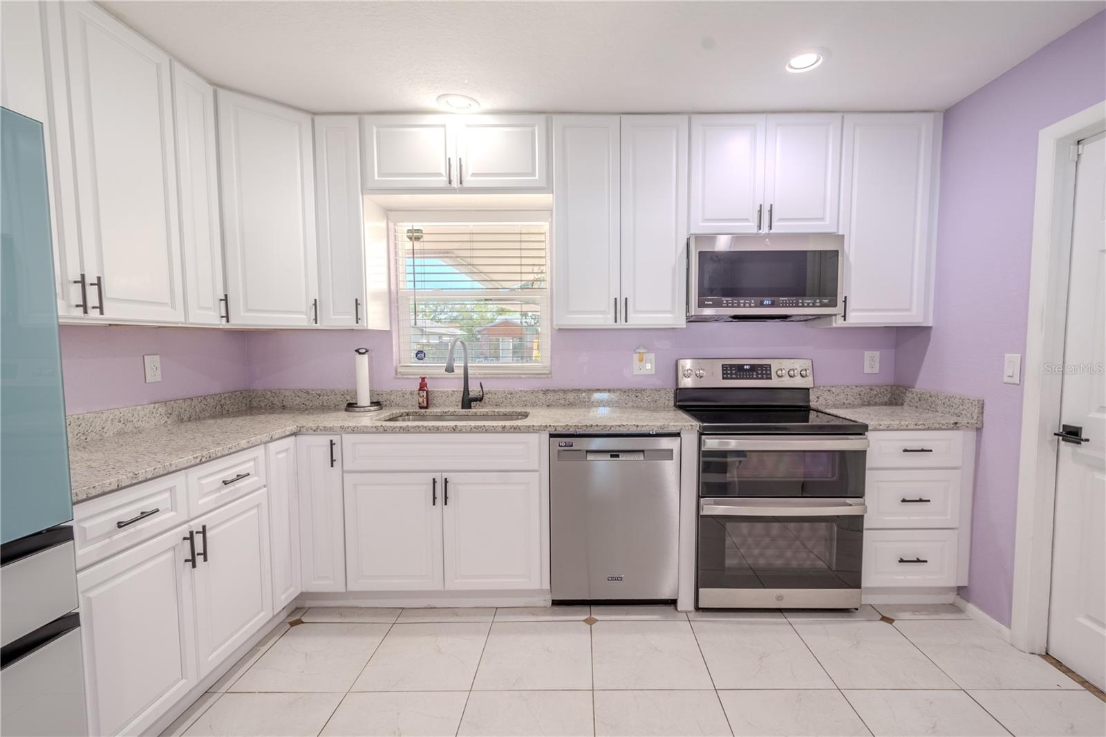 The kitchen features recessed lighting and ceramic tile floor.