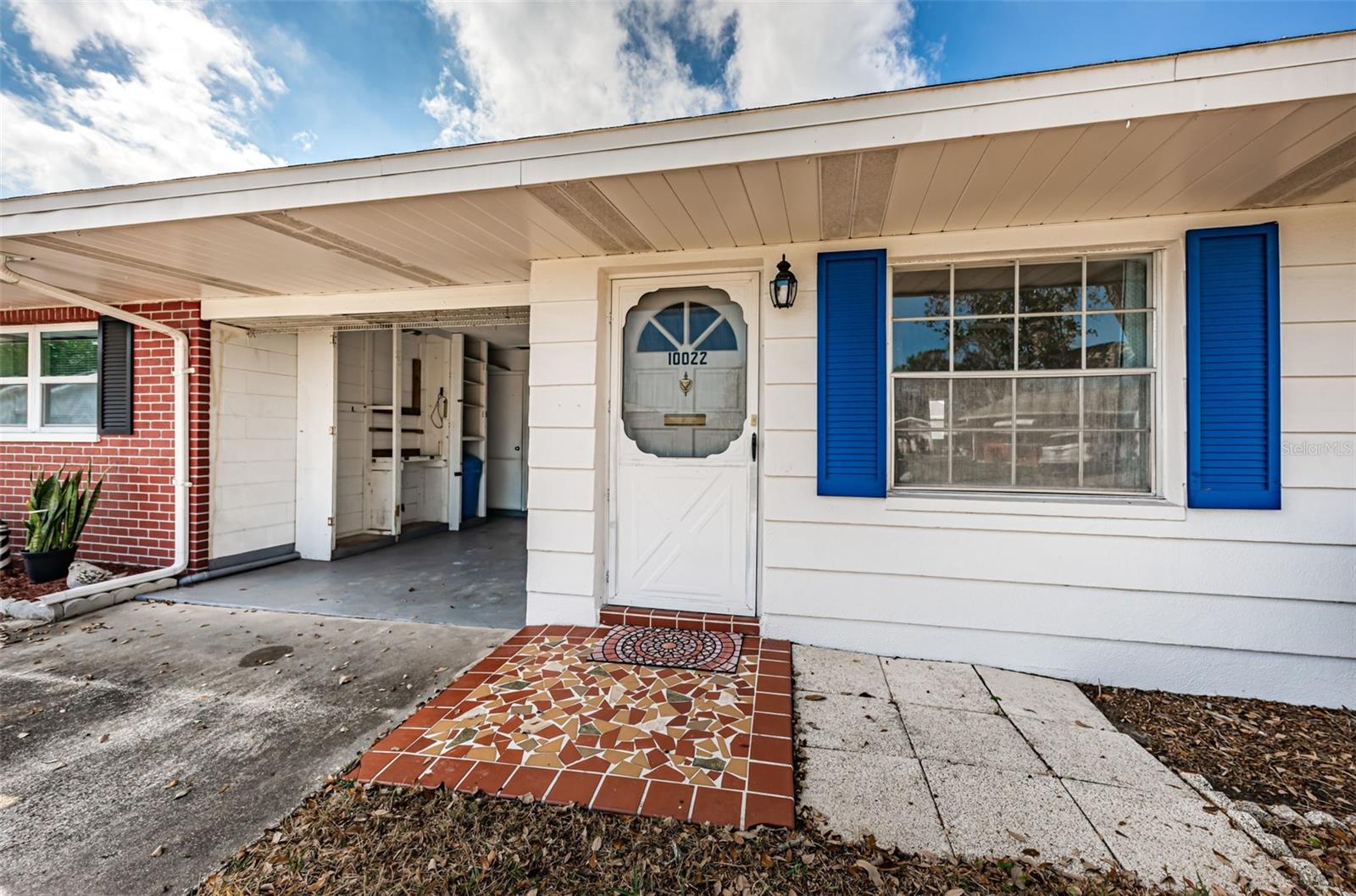 Front door with carport to the right and laundry