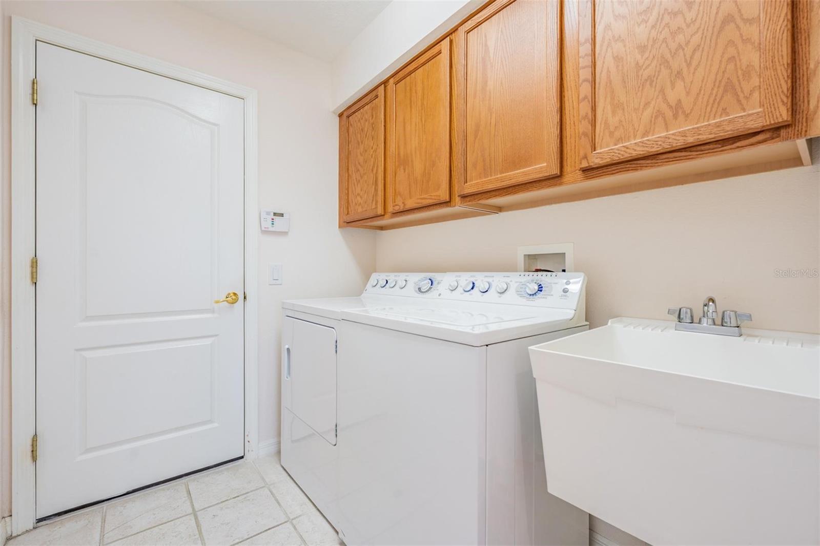 Walk in laundry room with utility sink and built-in cabinets