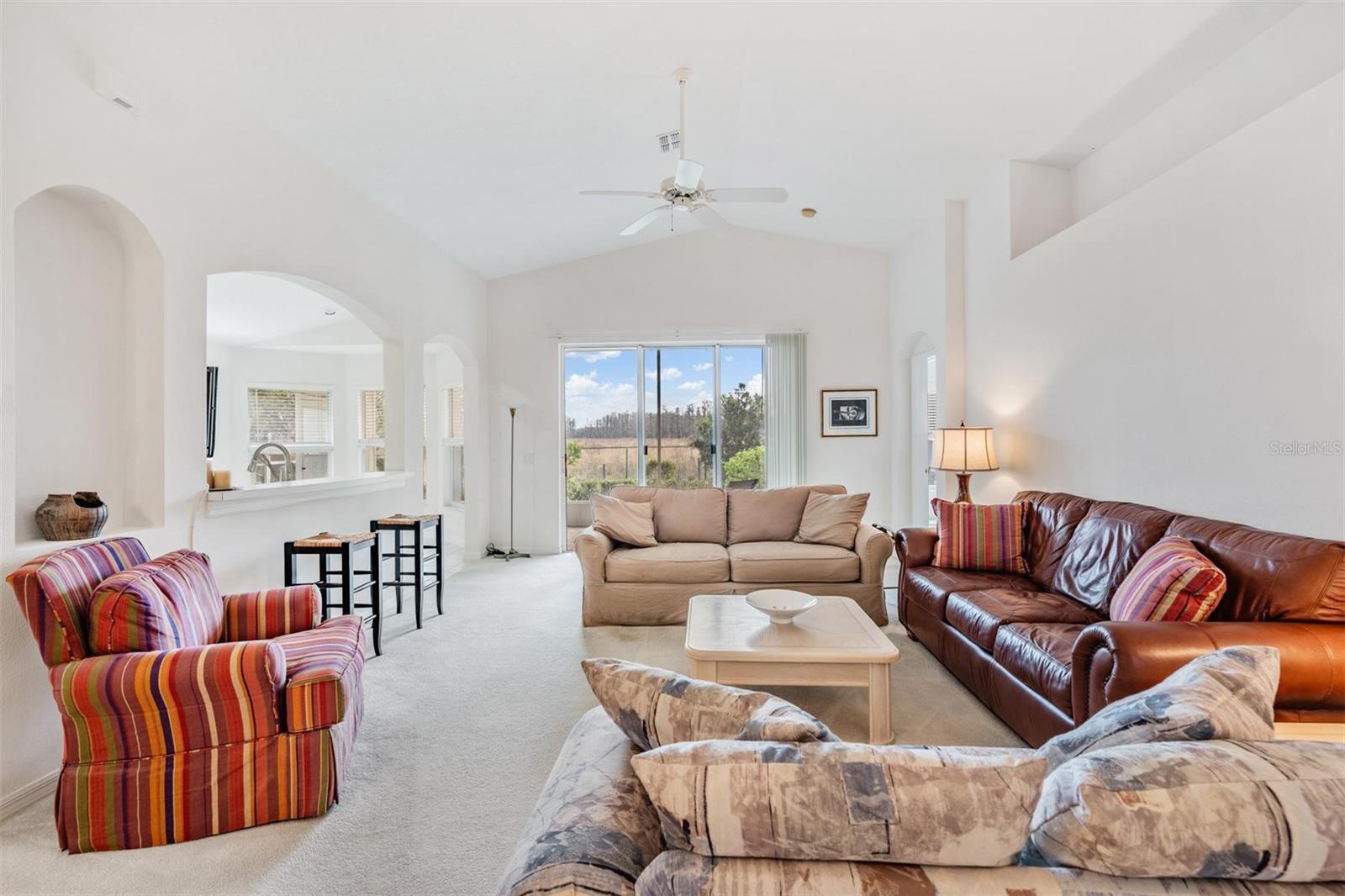 Vaulted great room with arched details and breakfast bar seating