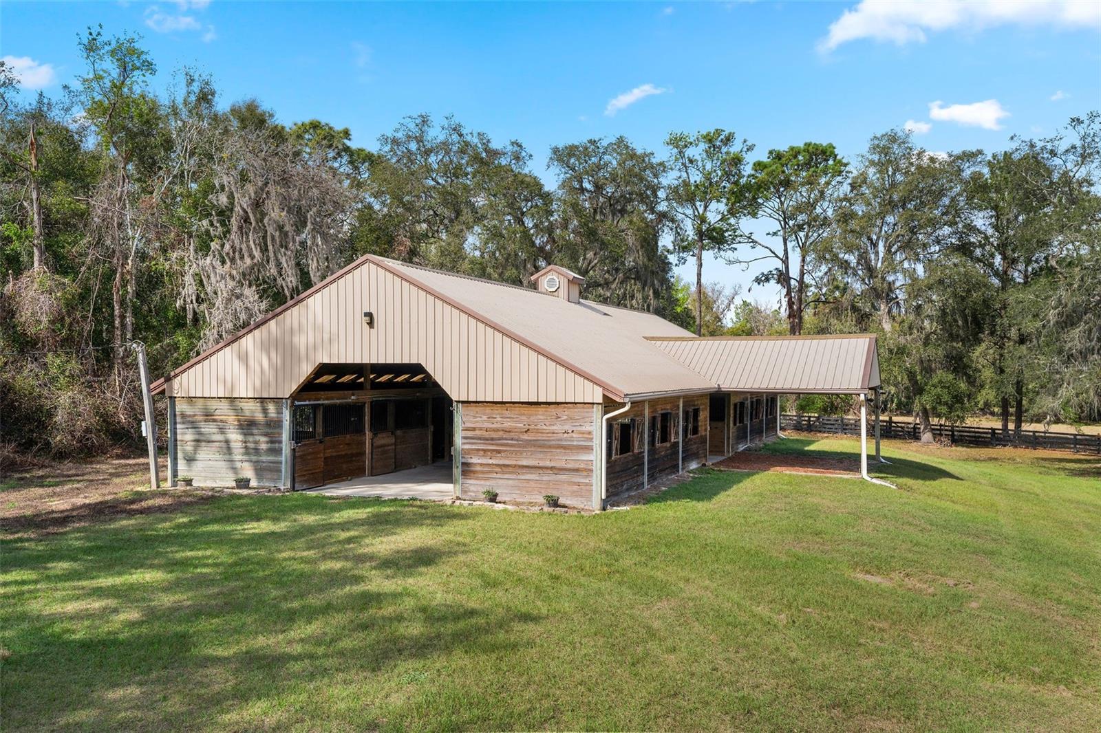 Center Aisle horse barn with 12 stables, tack room, electric, water, &  turnout paddocks