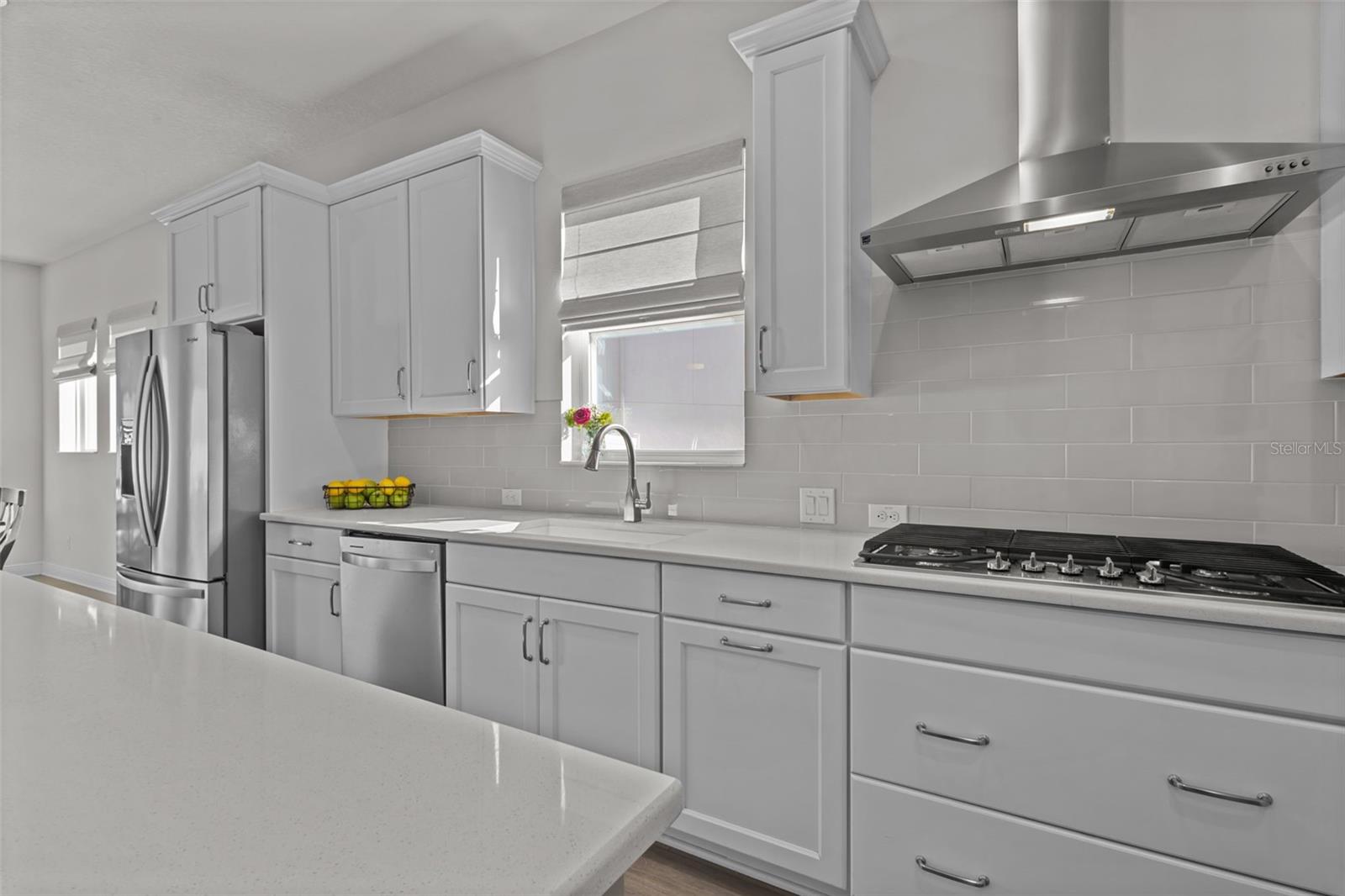 Kitchen -  spacious island, stylish backsplash, built-in stainless steel appliances, and a natural gas range